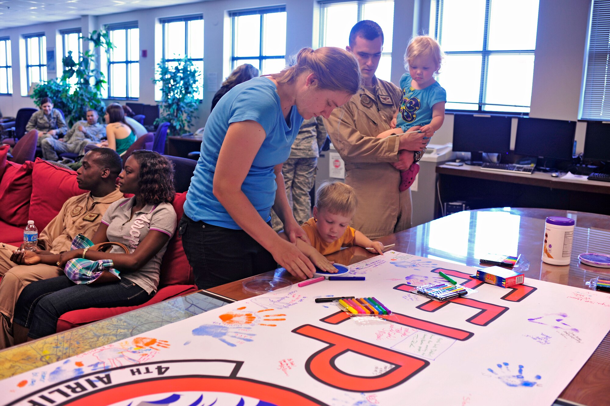 Family members of 1st Lt. Adriel Schoenhals, 4th Airlift Squadron pilot, sign a poster for deploying Airmen July 25, 2012, at Joint Base Lewis-McChord, Wash. Members of the 4th AS departed for a 60-day deployment to the Middle East. (U.S. Air Force photo/Staff Sgt. Frances Kriss)