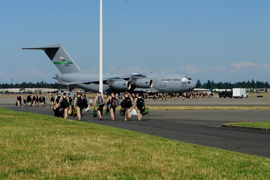 Members of the 4th Airlift Squadron walk toward a C-17 Globemaster III to depart for a 60-day deployment to the Middle East July 25, 2012, at Joint Base Lewis-McChord, Wash. The Airmen will take over operations of the 817th Expeditionary Airlift Squadron. As the 817th EAS, their mission is to provide global strategic airlift, airdrop, aeromedical evacuation and humanitarian relief, to create an air bridge for personnel, equipment and supplies throughout the assigned areas of responsibility. (U.S. Air Force illustration/Adamarie Lewis-Page)