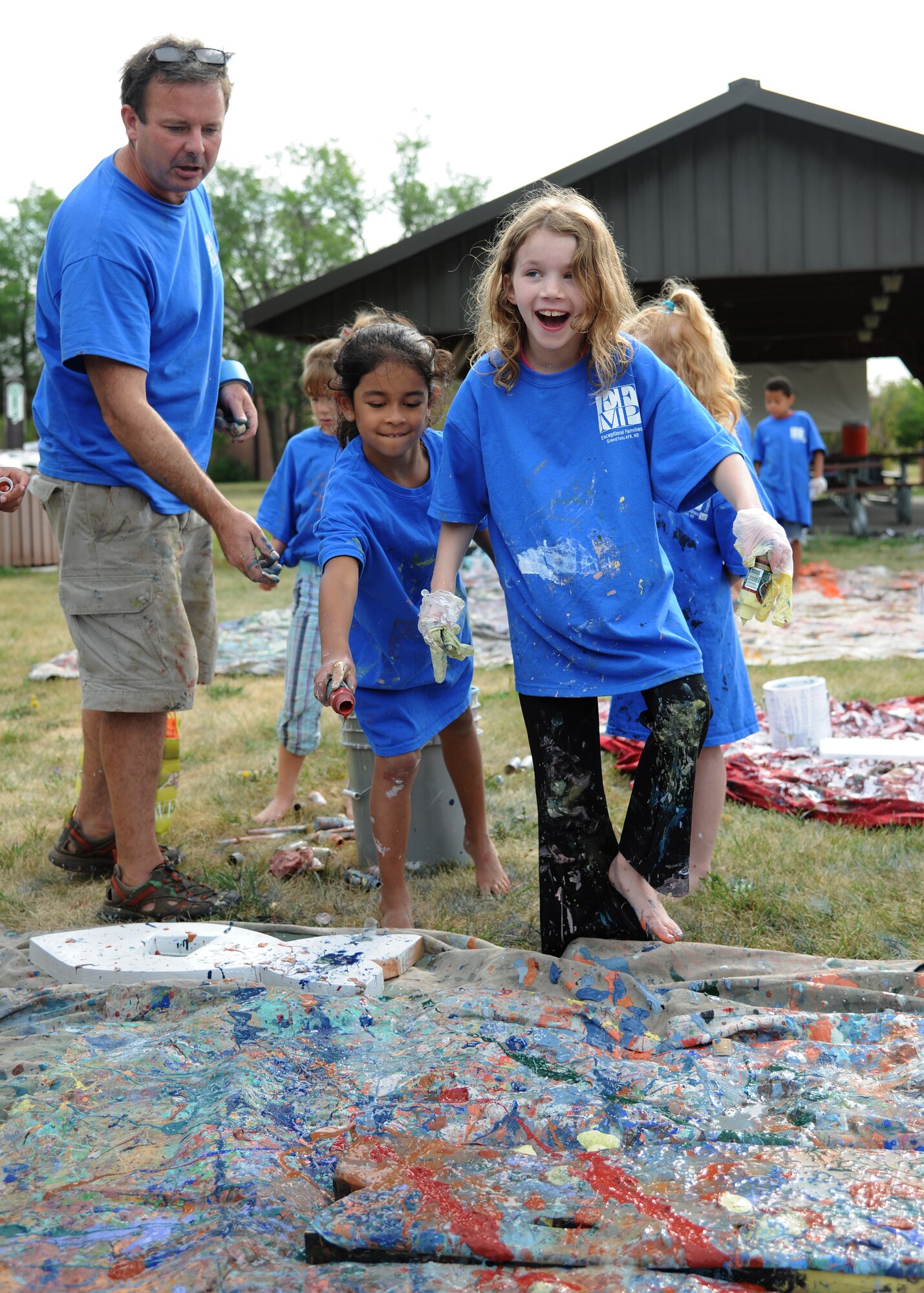 Katelynn Fennell splashes paint on a wooden fish at the Exceptional Family Member Program Art Camp, July 24, 2012, on Grand Forks Air Force Base, N.D.   About two dozen children participated in the camp and the completed project will be permanently mounted by the base pond.  (U.S. Air Force photo/Airman 1st Class Ashley N. Taylor)