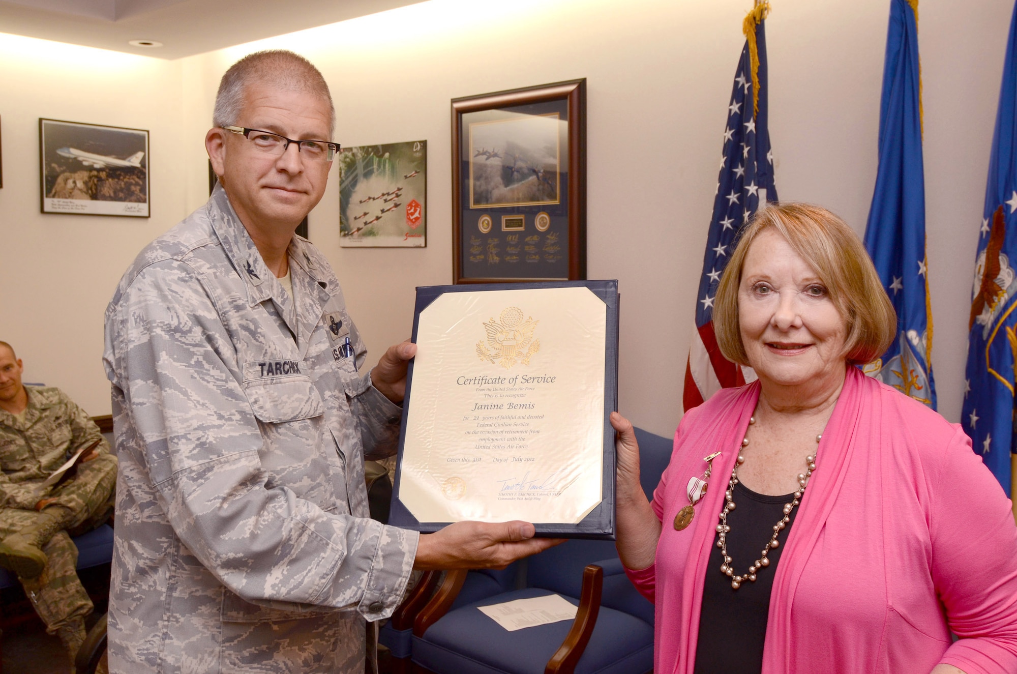 94th Airlift Wing Commander, Col. Tim Tarchick, presents Janine Bemis with a Federal Civilian Service certificate in recognition of her 21 years of U.S. government employment, July 26.  Ms. Bemis is ending her term of service as the 94th Airlift Wing Sexual Assault Response Coordinator on July 31st. (U.S. Air Force photo/ Brad Fallin)