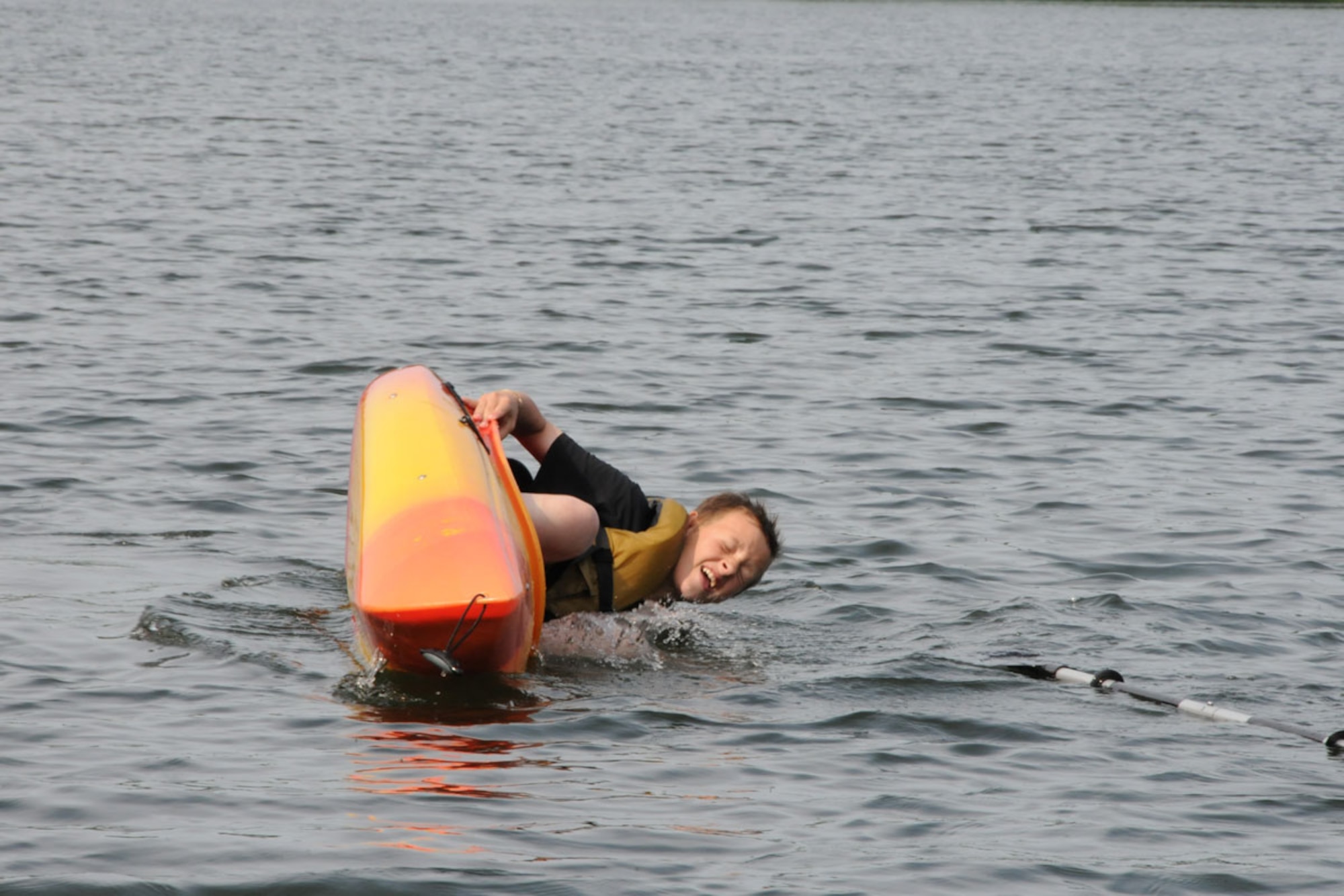 MacKenzie Wooden, a Boy Scout with JBER’s Troop 190 practices fl ipping a kayak at the Mirror Lake waterfront at Camp Gorsuch during the second week of camp.  Mackenzie took the kayaking merit badge at summer camp this year. Boy Scouts go to
camp every year to learn scouting skills that they will use later in life. (U.S. Air Force photo/Senior Airman Ross Whitley)