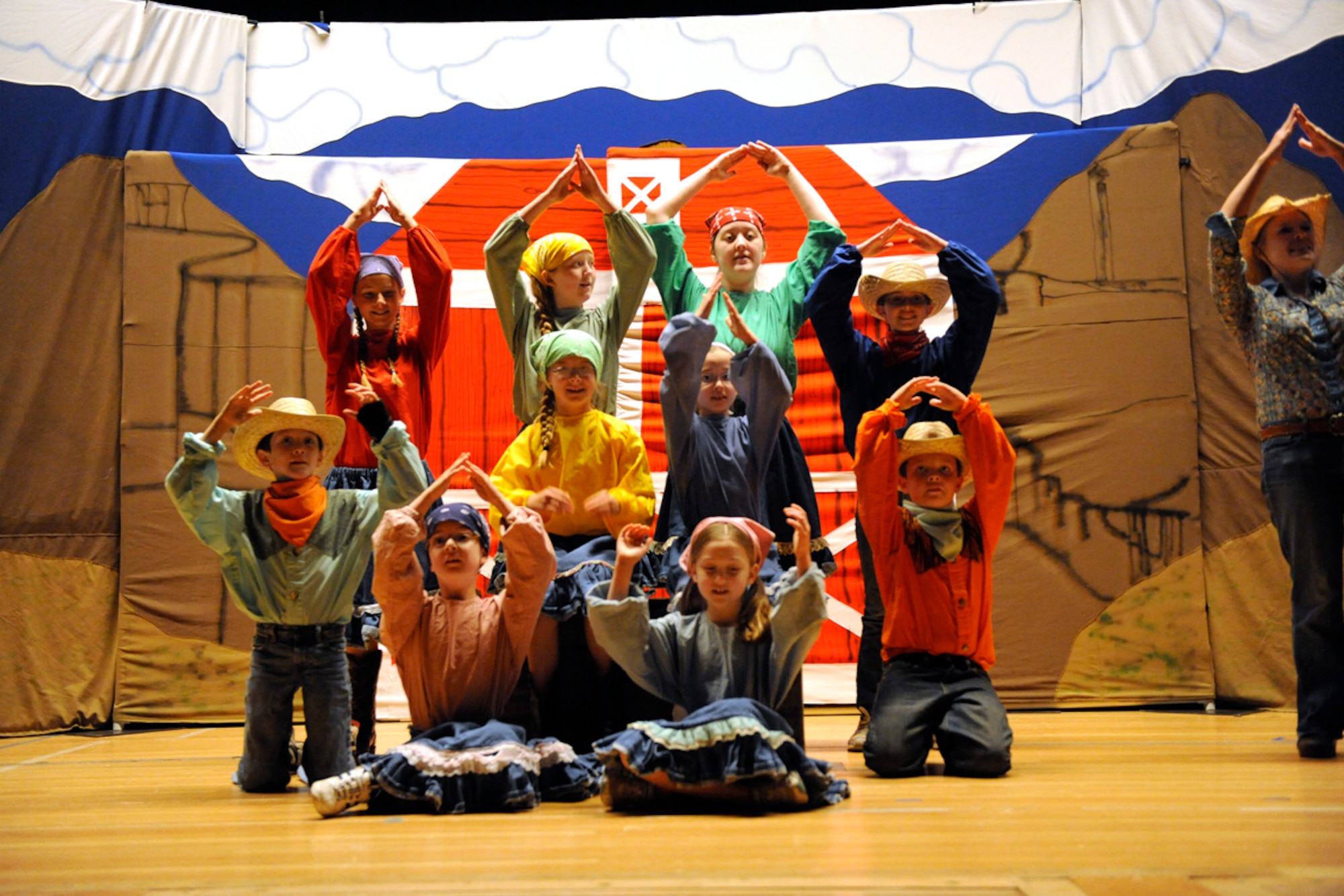 Children working with members of the Missoula Children's Theatre perform on stage during a "Beauty Lou and the Country Beast" rehearsal at the Elmendorf-side theater on Joint Base Elmendorf-Richardson, Alaska July 20. The show was arranged and put on by the Missoula Children's Theatre and also provided shows on July 13 on the Fort Richardson side. The theatre provides performances including comical twists on original fairy tales and other popular stories. (U.S. Air Force photo/Staff Sgt. Robert Barnett)