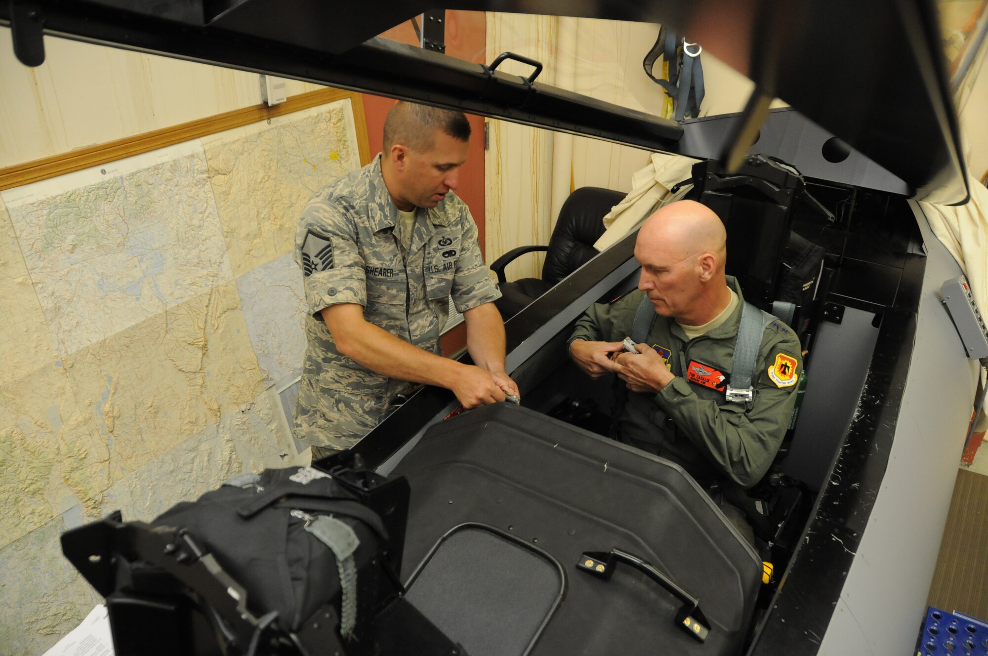 Master Sgt. Kenneth Shearer, 114th Fighter Squadron, instructs Maj. Gen. Timothy Zadalis, Director of Intelligence Operations and Nuclear Integration Headquarters at Air Education and Training Command, on F-15 egress in preparation for Zadalis' familiarization flight in an F-15 Eagle at Kingsley Field, Ore., July 24, 2012. Kingsley Field was just moved under the command of Zadalis earlier this year. (Air National Guard photo by Tech. Sgt. Jefferson Thompson/Released)