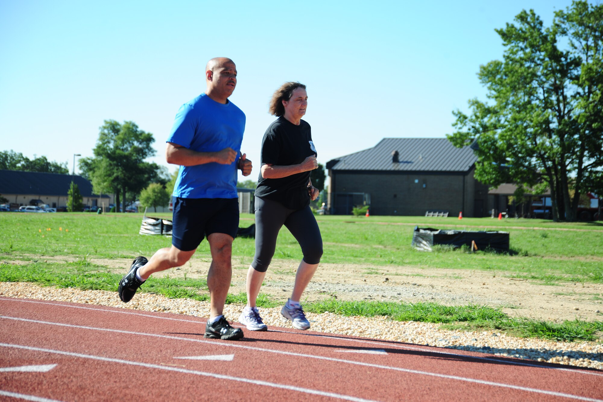 Ann Carlson and Senior Master Sgt. David Bennet, who work at the Air National Guard Readiness Center on the east side of Andrews, running on the East Fitness Center's resurfaced running track July 25. The EFC is open Monday – Friday, from 6am to 6pm. (U.S. Air Force photo/Senior Airman Amber Russell)