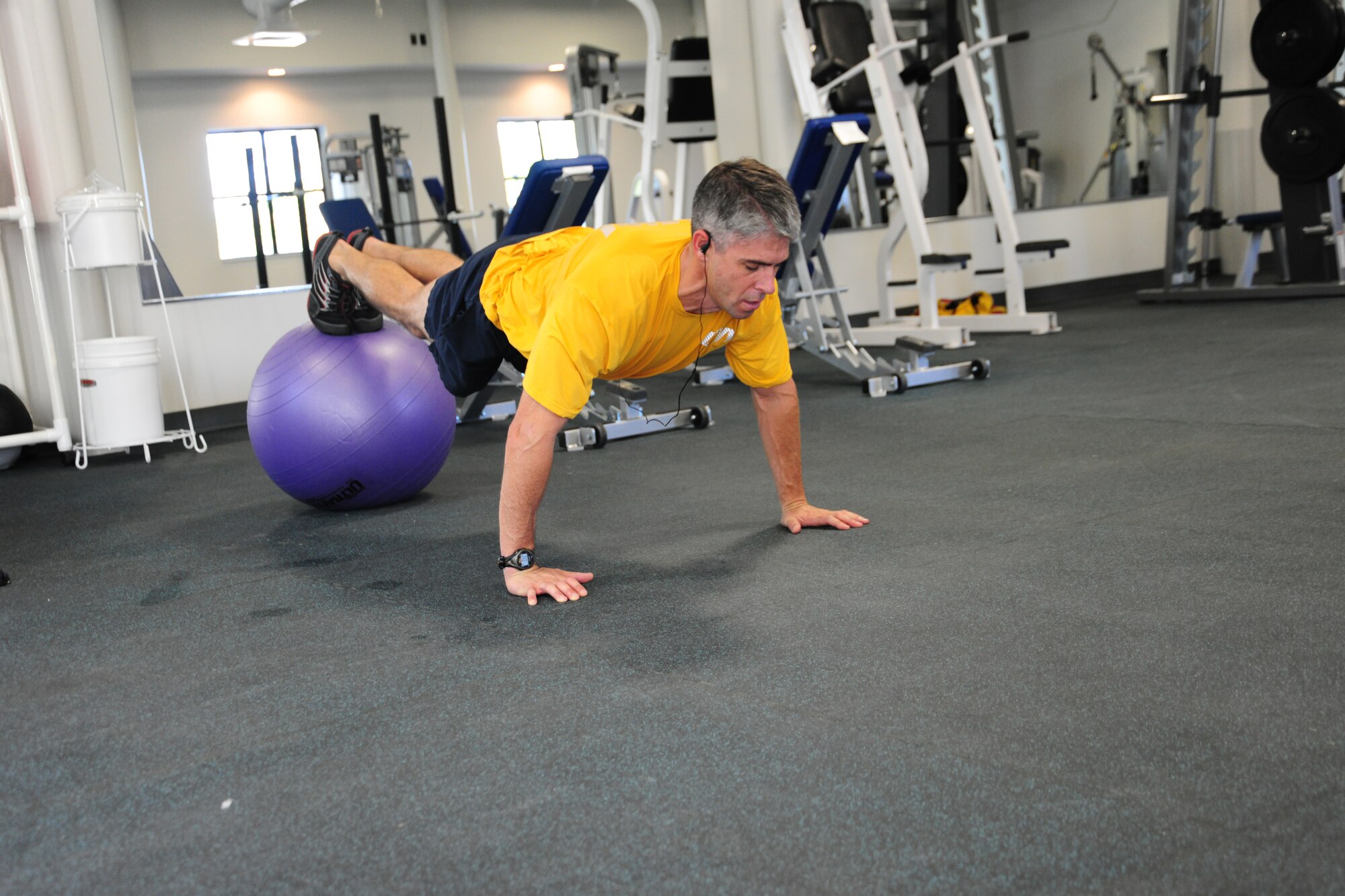 Navy Cmdr. Mike Graben,  Naval Facility Washington Chief Staff Officer,  works his core at the East Fitness Center's newly-renovated mini-tactical/weight room July 25. The EFC is open Monday – Friday, from 6am to 6pm. (U.S. Air Force photo/Senior Airman Amber Russell)