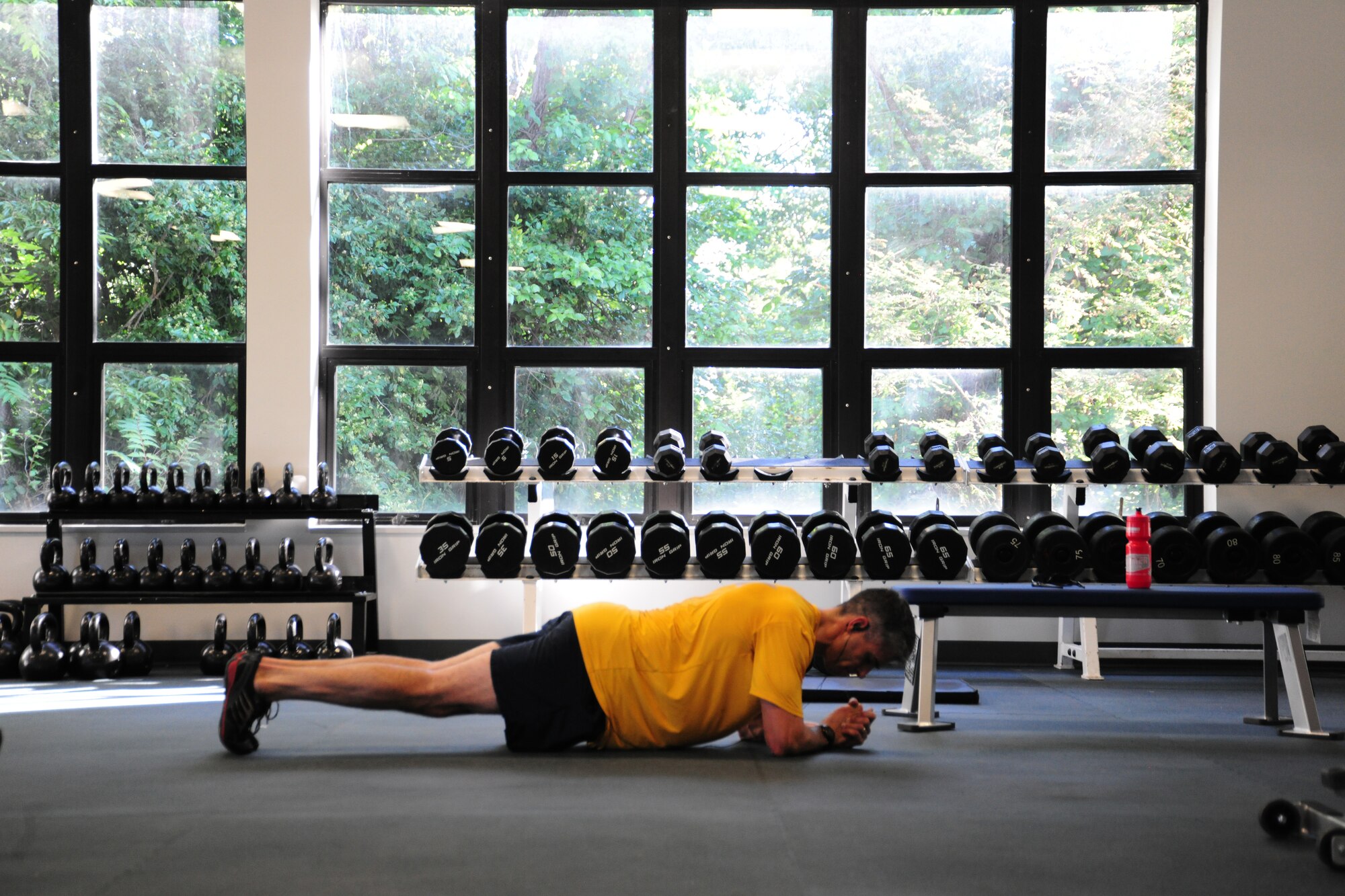 Navy Cmdr. Mike Graben, Naval Facility Washington Chief Staff Officer, sweats out some planks at the East Fitness Center's newly renovated mini-tactical/weight room July 25, 2012 . The room includes new weight-lifting equipment, new flooring and new Rogue tactical weights. (U.S. Air Force photo/Senior Airman Amber Russell)