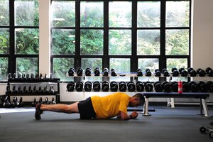 Navy Cmdr. Mike Graben, Naval Facility Washington Chief Staff Officer, sweats out some planks at the East Fitness Center's newly renovated mini-tactical/weight room July 25, 2012 . The room includes new weight-lifting equipment, new flooring and new Rogue tactical weights. (U.S. Air Force photo/Senior Airman Amber Russell)
