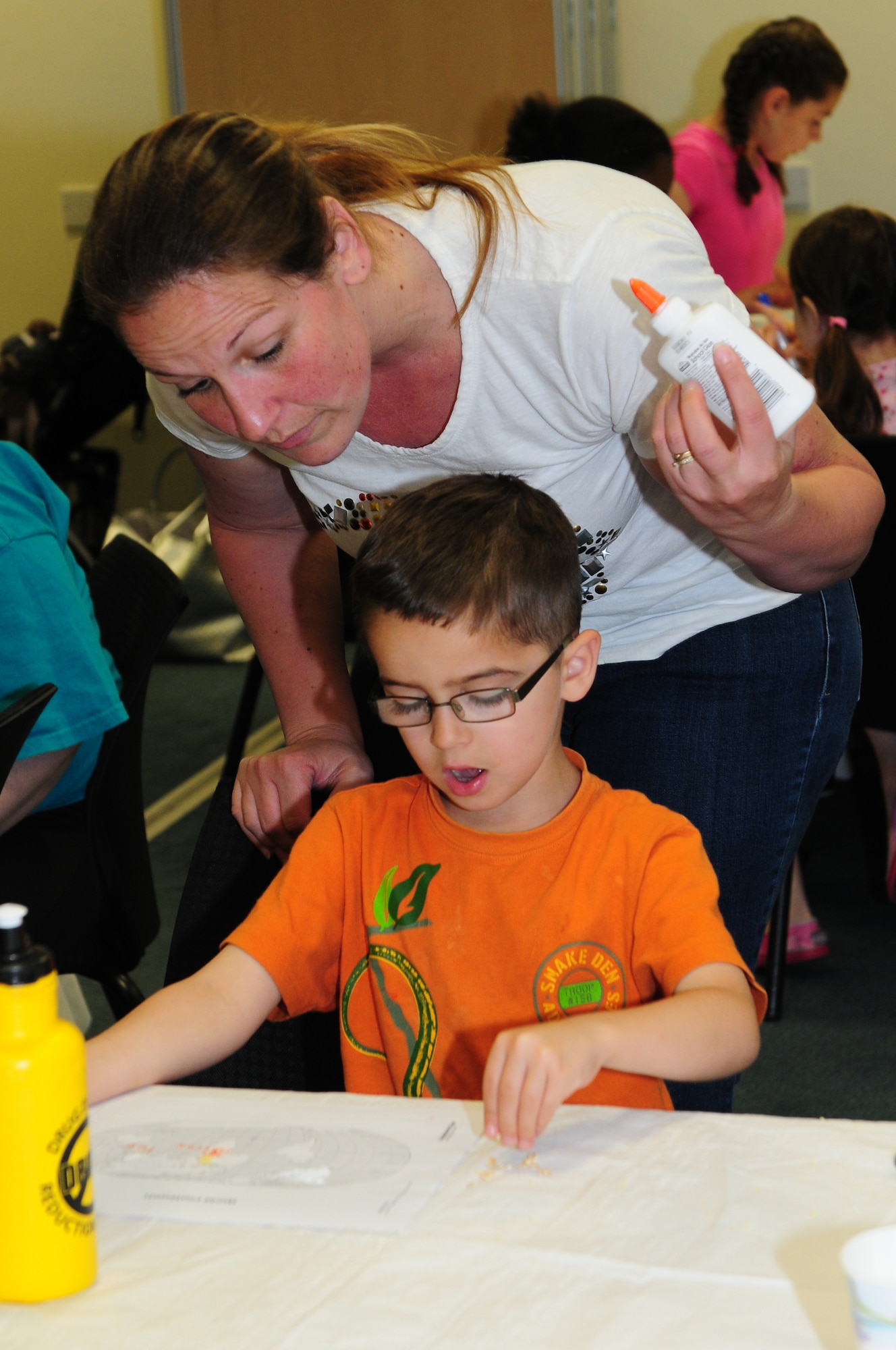 ROYAL AIR FORCE LAKENHEATH, England – Laurel Jalafka helps Thomas Clay, 6, with an educational art project during a food play-date July 25, 2012. The 48th Medical Group Health and Wellness Center hosted the food play-date all week promoting healthy living to children through nutritional activities and fun exercises. (U.S. Air Force photo by Airman 1st Class Cory D. Payne)