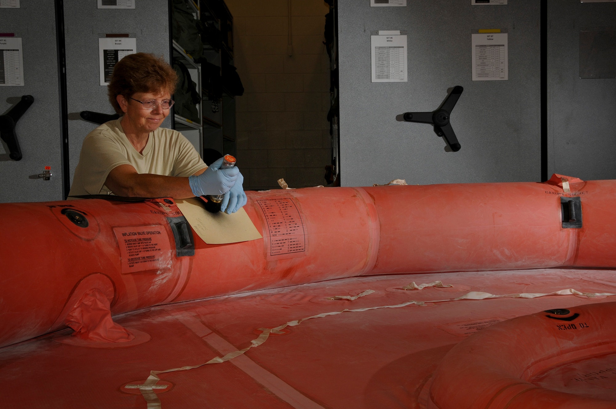 Tech. Sgt. Cynthia Baum, 911th Operations Support Squadron aircrew flight equipment technician, stencils additional information on a new F2B 20-man life raft, here, July 19, 2012. The stenciling is part of an annual inspection to ensure that the raft is operating properly and have all of the correct markings to help aircrew out in case of an emergency. There are four life rafts on each C-130 Hercules in case the aircraft must emergency land in water. (U.S. Air Force photo by Senior Airman Joshua J. Seybert/Released))