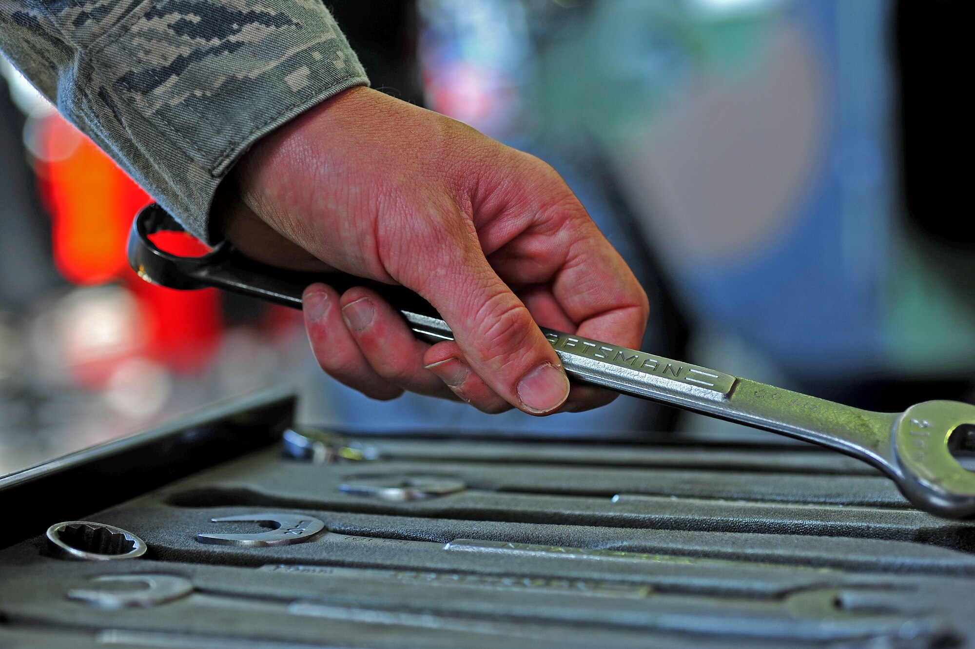 Airman 1st Class Will Mansfield, 86th Vehicle Readiness Squadron vehicular maintenance mechanic, picks up a 22-millimeter combination wrench at the 86th VRS general purpose light shop on Ramstein Air Base, Germany, July 12, 2012. The 43 members of GP Light work hard year-round to provide premier full-service vehicle operations and management support to members of Team Ramstein and associate units across Europe and Africa. (U.S. Air Force photo/Airman 1st Class Holly Cook)