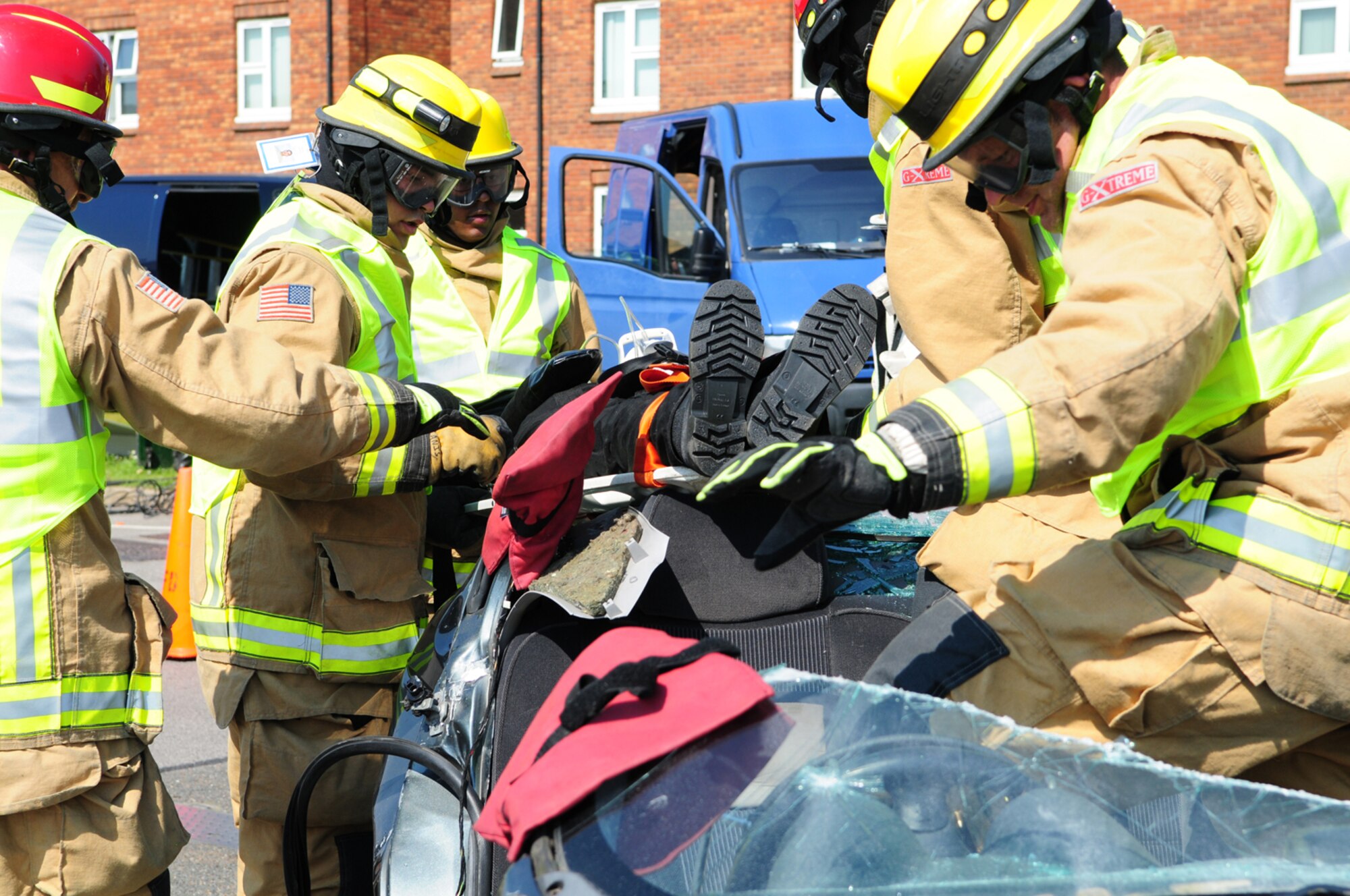RAF MILDENHALL, England – Firefighters from the 100th Civil Engineer Squadron Fire Department remove a simulated casualty from an extricated vehicle July 25, 2012, at the Exchange parking lot. During the training scenario, the firefighters responded to a vehicle accident with one trapped driver with injuries. Rather than remove the casualty from the vehicle, the responders removed the vehicle from the casualty and carefully cut the car away before safely removing the injured person. (U.S. Air Force photo/Karen Abeyasekere)