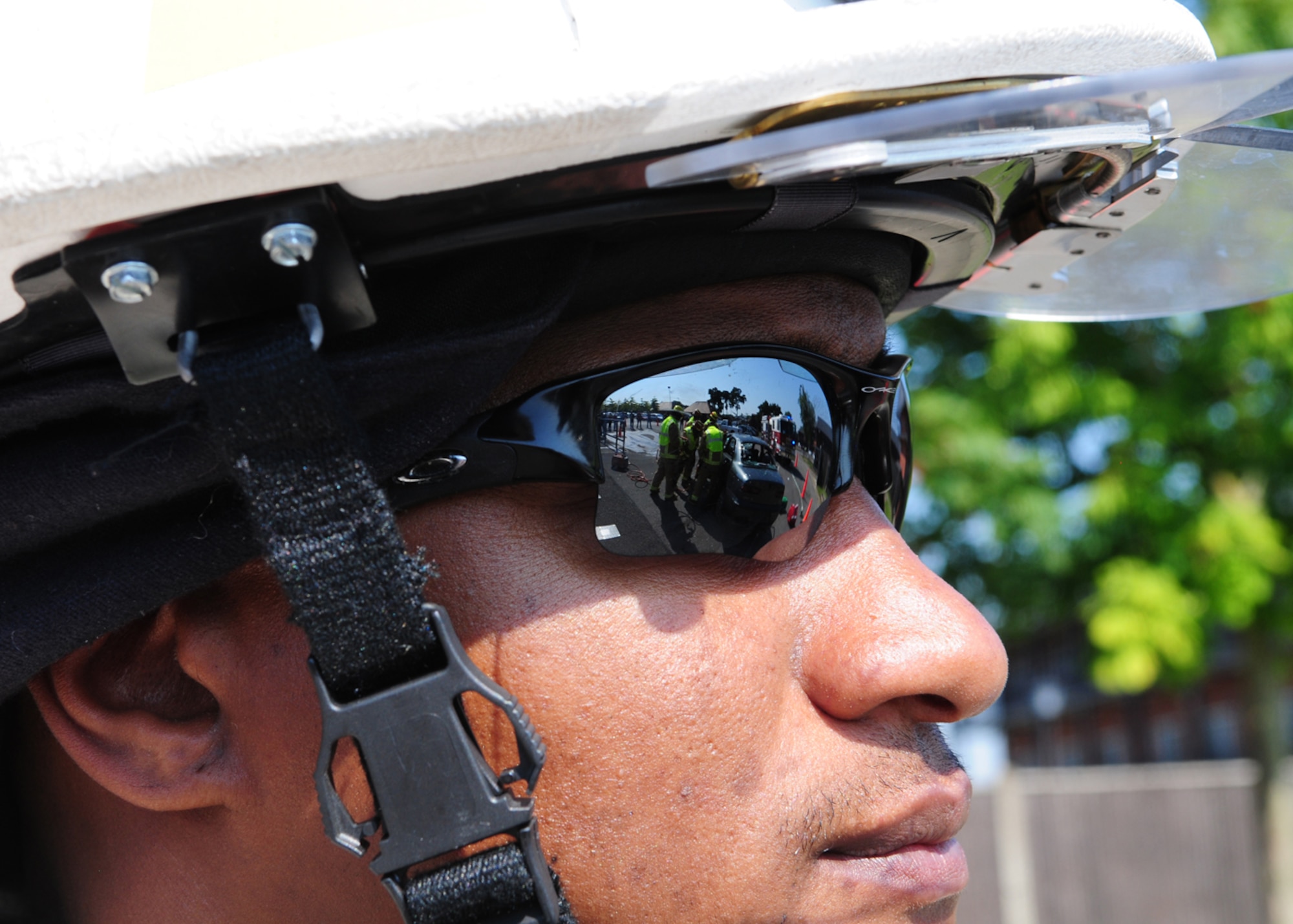 RAF MILDENHALL, England – Master Sgt. Corey Coleman, 100th Civil Engineer Squadron Fire Department, observes his team of firefighters during a training scenario and demonstration at the Exchange parking lot July 25, 2012. Coleman was incident commander at the scene, and was on hand to ensure everything was performed correctly and safely. The scenario involved a simulated vehicle accident, resulting in an injured, trapped driver. In cases such as this, the firefighters carefully remove the vehicle from the casualty, rather than the casualty from the vehicle. As they were unable to gain access through the doors, a crew chief made the decision to gain entry by cutting off the roof, with which Coleman agreed. (U.S. Air Force photo/Karen Abeyasekere)