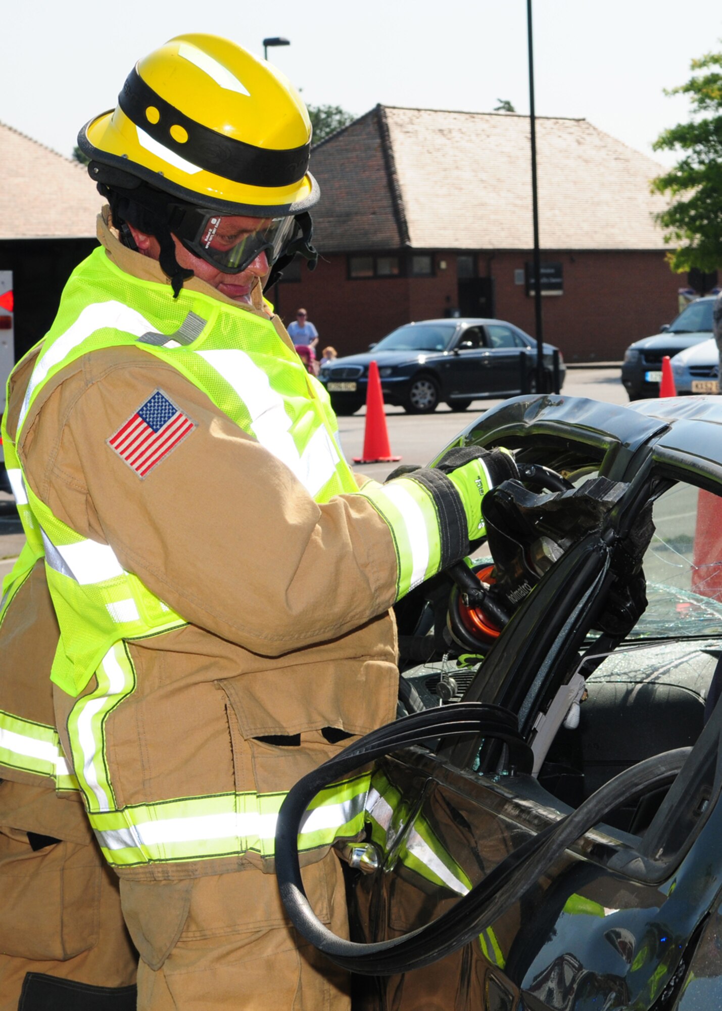 RAF MILDENHALL, England – Defence Fire Service Firefighter Jason French, 100th Civil Engineer Squadron Fire Department, uses a combination tool to cut through a door jamb on a car during a demonstration and training exercise July 25, 2012, at the Exchange parking lot. The display also included a grease pan fire demonstration and fire extinguisher training. (U.S. Air Force photo/Karen Abeyasekere)
