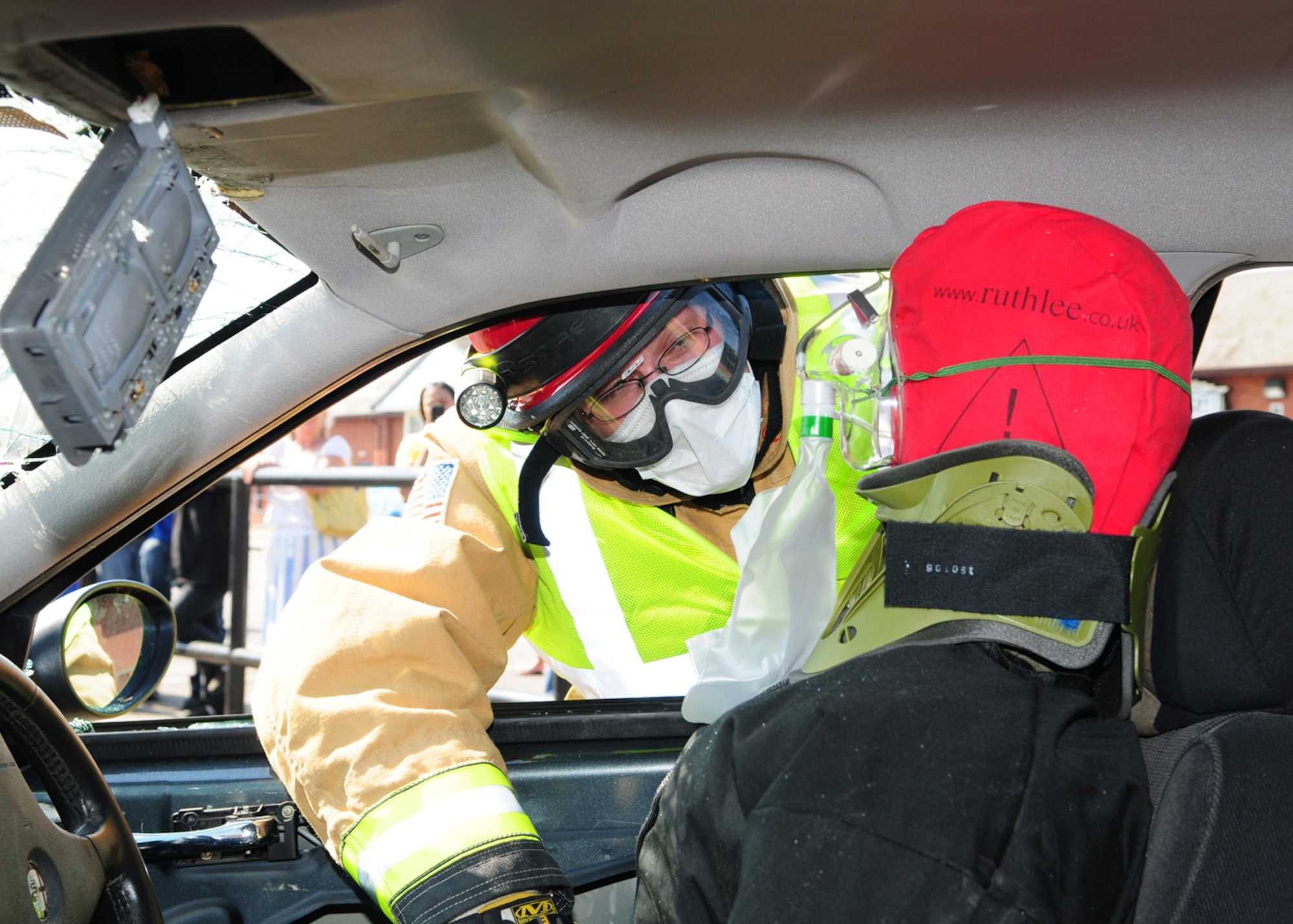 RAF MILDENHALL – Staff Sgt. Aaron Schofield, 100th Civil Engineer Squadron Fire Department, supports a simulated casualty in a car being extricated during a demonstration at the Exchange parking lot July 25, 2012. In addition to a grease pan fire demonstrator and fire extinguisher training, firefighters showed how they respond to vehicle accidents and cut the roof off a vehicle to rescue those inside. (U.S. Air Force photo/Karen Abeyasekere)