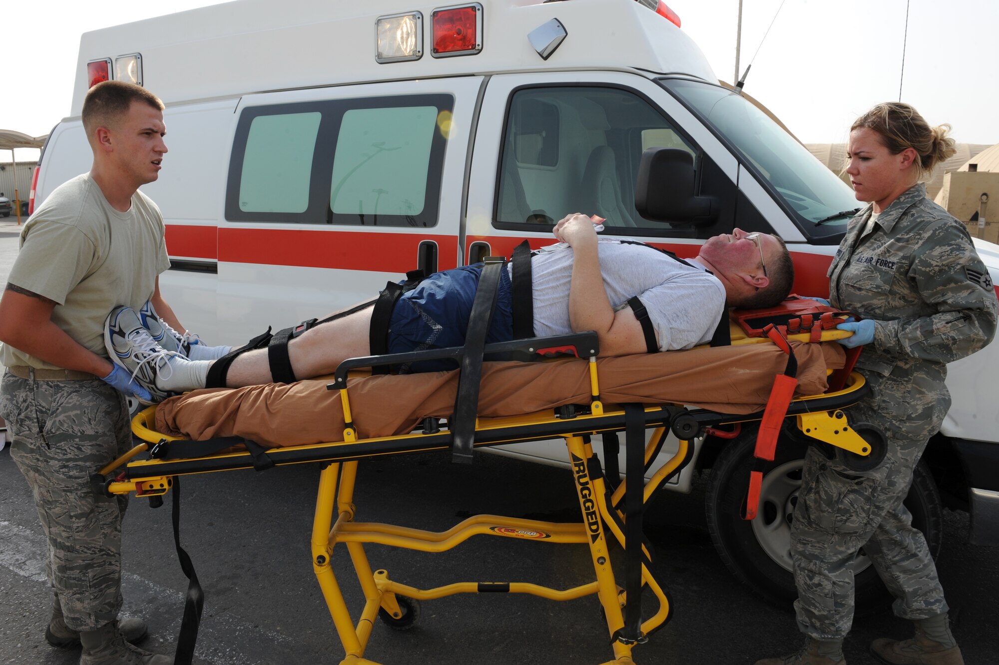 SOUTHWEST ASIA - U.S. Air Force Staff Sgt. Matthew Salyers, 380th Expeditionary Civil Engineer Squadron Fire Department member, and Senior Airman Victoria Thompson, 380th Expeditionary Medical Group member, transport a patient to an ambulance during a major accident response exercise at the 380th Air Expeditionary Wing July 25, 2012. The exercise tested the wing's ability to respond to a major accident. (U.S. Air Force photo/Master Sgt. Scott MacKay)