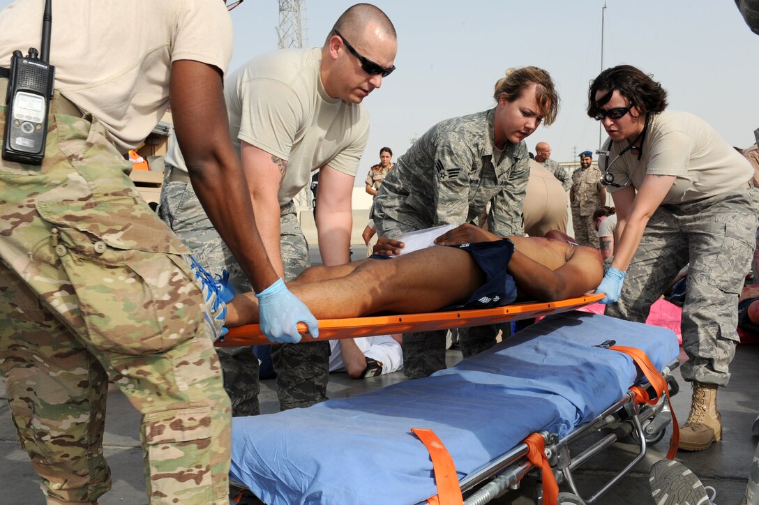 SOUTHWEST ASIA - Members of the 380th Expeditionary Medical Group lift a patient onto a gurney during a major accident response exercise at the 380th Air Expeditionary Wing July 25, 2012. The exercise tested the wing's ability to respond to a major accident. (U.S. Air Force photo/Master Sgt. Scott MacKay)
