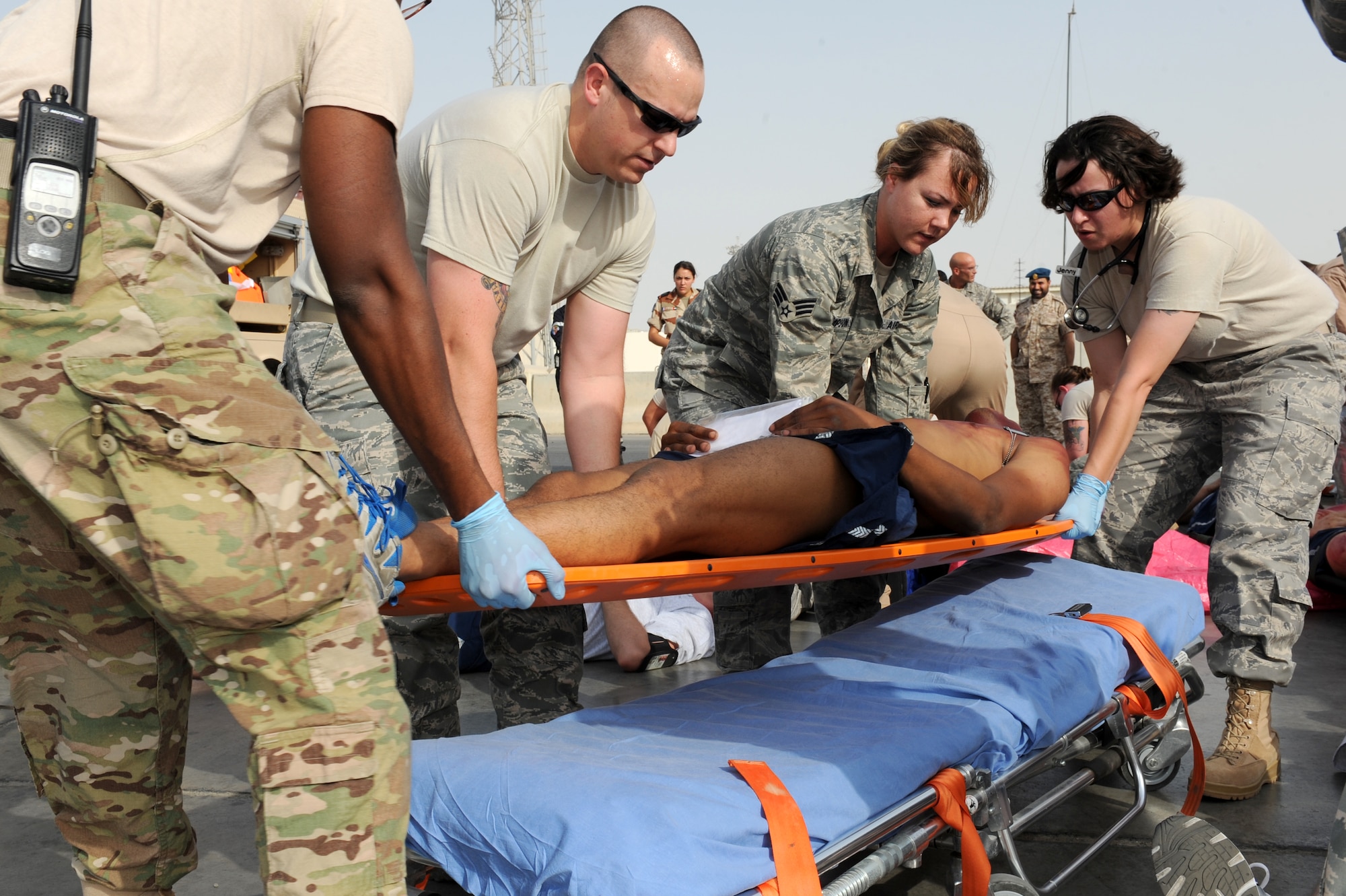 SOUTHWEST ASIA - Members of the 380th Expeditionary Medical Group lift a patient onto a gurney during a major accident response exercise at the 380th Air Expeditionary Wing July 25, 2012. The exercise tested the wing's ability to respond to a major accident. (U.S. Air Force photo/Master Sgt. Scott MacKay)