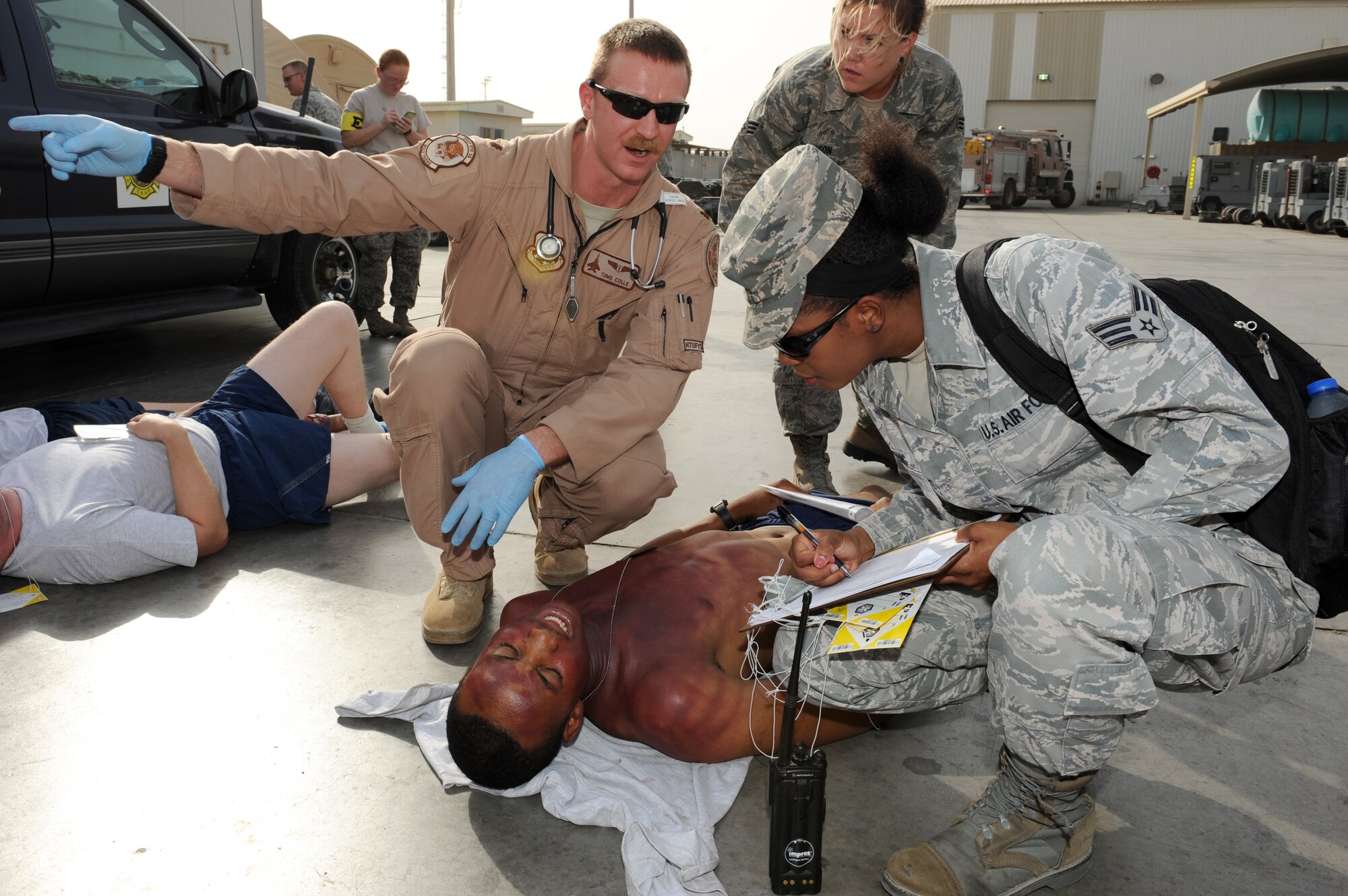 SOUTHWEST ASIA - U.S. Air Force Maj. (Dr.) Noel Colls discusses care of a patient with Senior Airman Camille Chang as Senior Airman Victoria Thompson looks on during a major accident response exercise at the 380th Air Expeditionary Wing July 25, 2012. Colls, Chang and Thompson are all members of the 380th Expeditionary Medical Group.  (U.S. Air Force photo/Master Sgt. Scott MacKay)