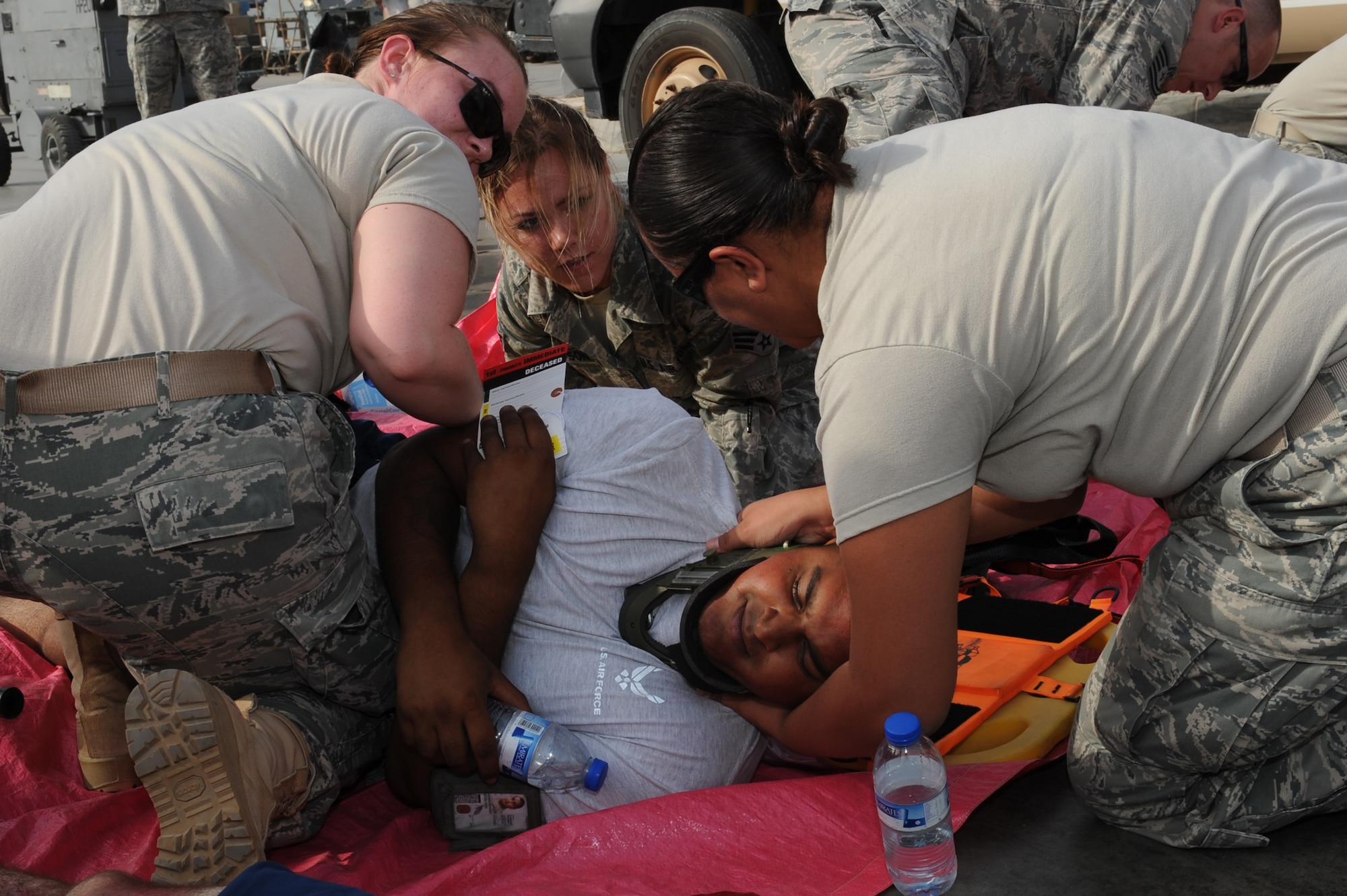 SOUTHWEST ASIA - U.S. Air Force Senior Airmen Shauna Grooms and Victoria Thompson, and Staff Sgt. Digna Ramos, 380th Expeditionary Medical Group members, provide aid to a wounded Airman during a major accident response exercise at the 380th Air Expeditionary Wing July 25, 2012. The exercise focused on the actions of first responders, including the fire department, security forces and medical personnel. (U.S. Air Force photo/Master Sgt. Scott MacKay)