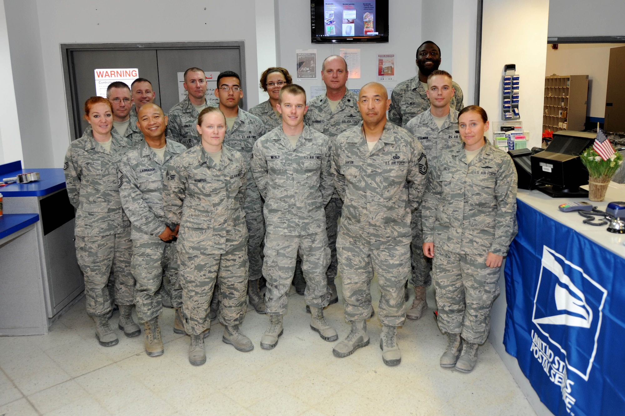 Members from the 379th Expeditionary Communications Squadron pose for a group photo in Southwest Asia, July 24, 2012. Airmen from the 379th ECS Network Management and the Post office worked together to ensure the first Air Force contingency debit/credit card transaction service in the AOR was successful  ultimately improving customer service to deployed Airmen.  (U.S. Air Force photo/Staff Sgt. Sheila deVera)