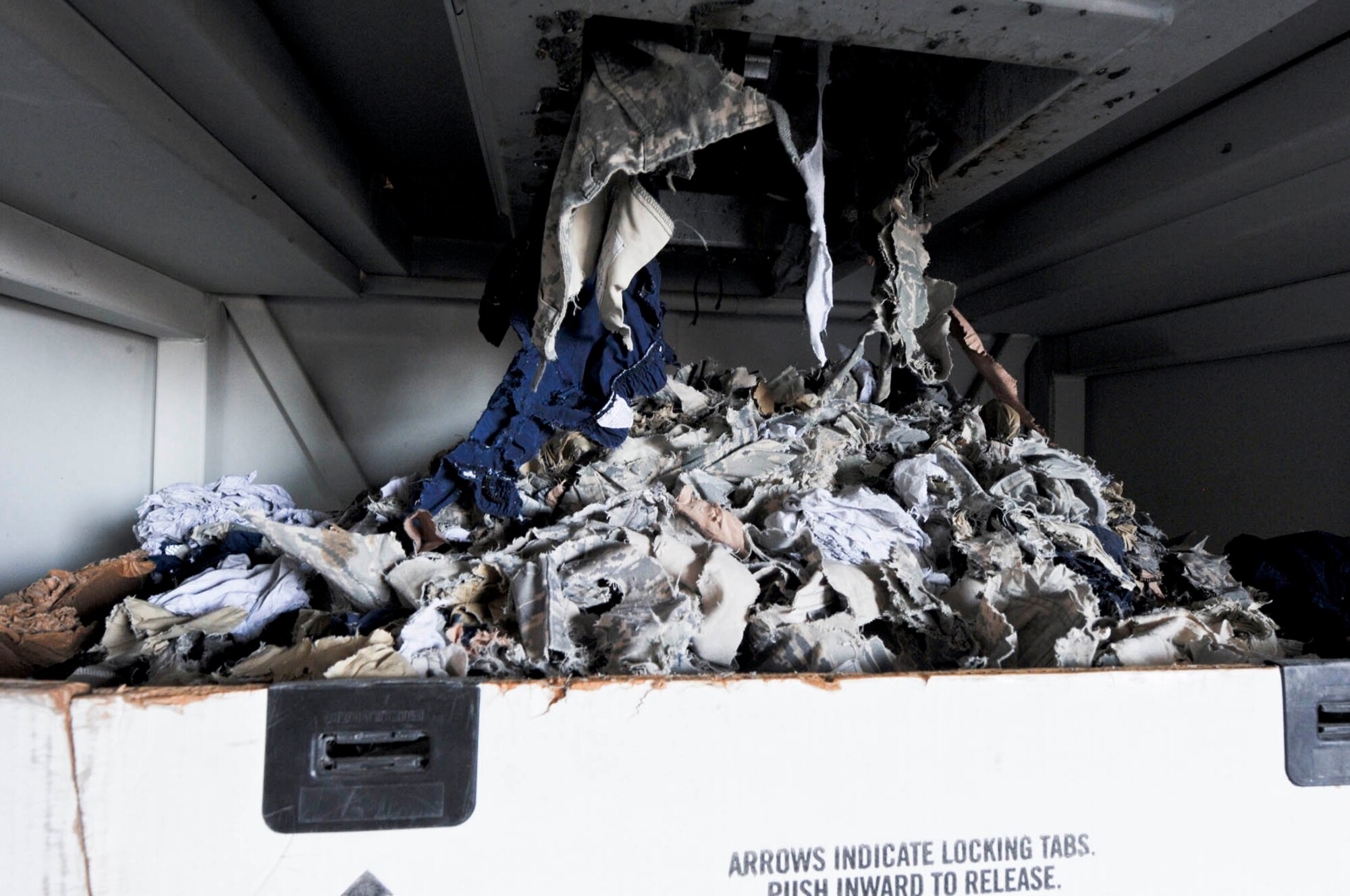 Shredded unserviceable uniforms pile up after going through the ?Crusher? machine in Southwest Asia, July 24, 2012. The 379th Air Expeditionary Wing Force Protection collects and sorts through the discarded uniforms prior to shredding the items left by service members. (U.S. Air Force photo/Staff Sgt. Sheila deVera)
