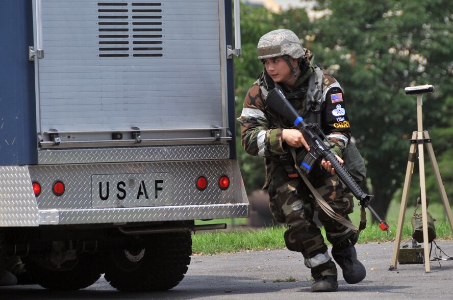 Senior Airman Daniel Jackson, 51st Civil Engineer Squadron, maneuvers from his cover position behind a Chemical, Biological, Radiological, and Nuclear vehicle during operational readiness exercise Beverly Midnight 12-03 at Osan Air Base, Republic of Korea, July 26, 2012. Throughout the week, Osan Mustangs demonstrate the ability to operate in a chemical environment as well as administer self-aid and buddy-care during a wartime environment. BM 12-03 is the fourth ORE for Team Osan in 2012. (U.S. Air Force photo/Staff Sgt. Craig Cisek)