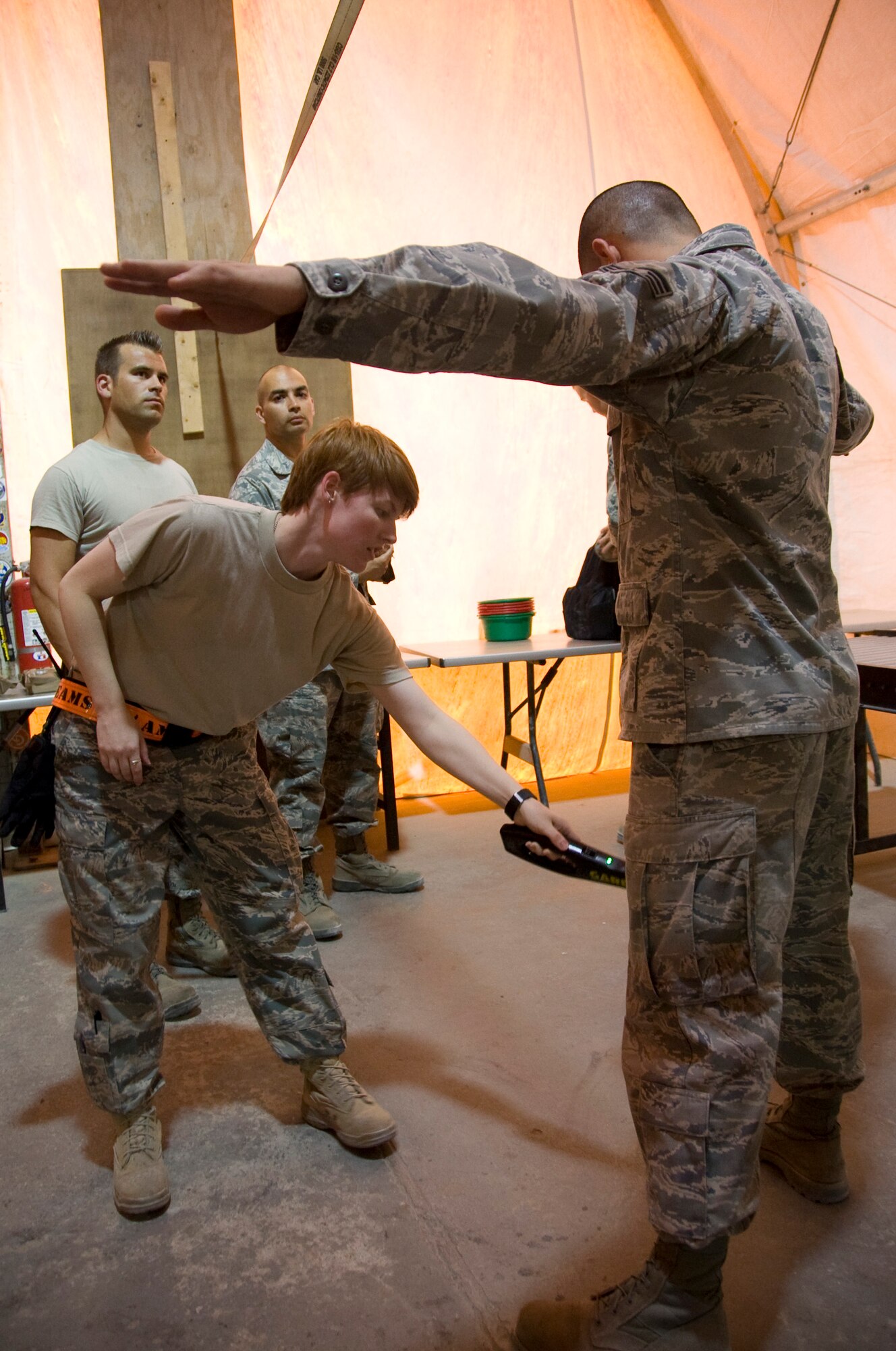 Airman 1st Class Patricia Sloan, 8th EAMS passenger service representative, uses a hand-held metal detector to scan departing service members before they head home from a successful deployment in Southwest Asia July 22, 2012. One of the top priorities of the Airmen of the 8th EAMS is to ensure all passengers traveling to the continental United States adhere to the Transportation Security Administration guidelines. (U.S. Air Force photo/Senior Airman Bryan Swink)