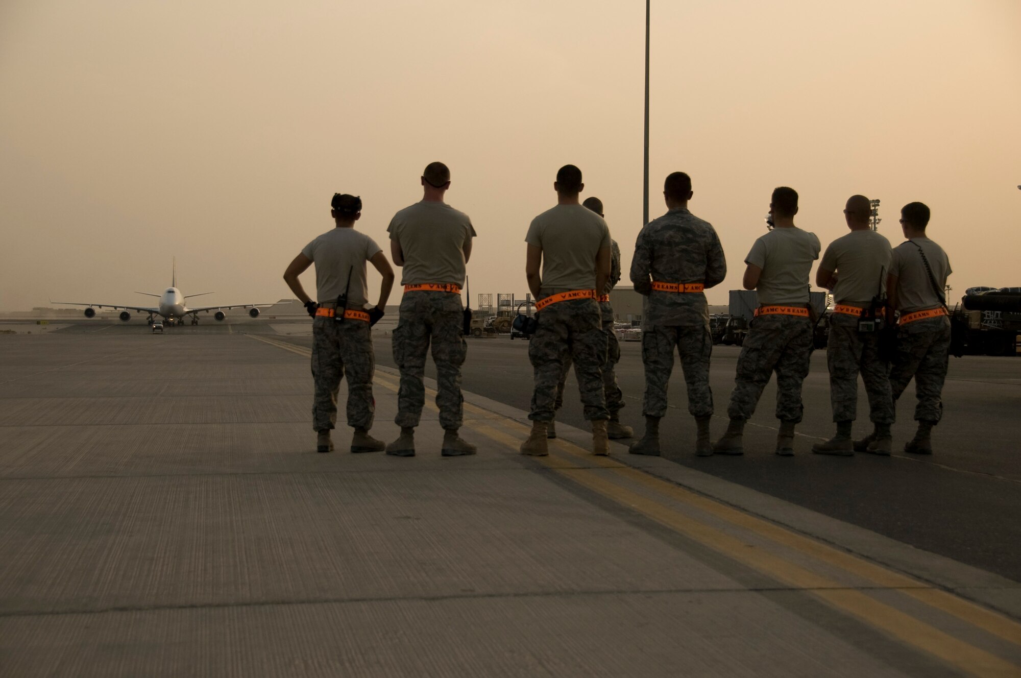 Port Dawgs from the 8th Expeditionary Air Mobility Squadron await the arrival of an aircraft containing approximately 350 incoming service members July 22, 2012 in Southwest Asia. The baggage team ensures all luggage is successfully removed from the aircraft and ready for pickup by the time each person processes through immigration. (U.S. Air Force photo/Senior Airman Bryan Swink)