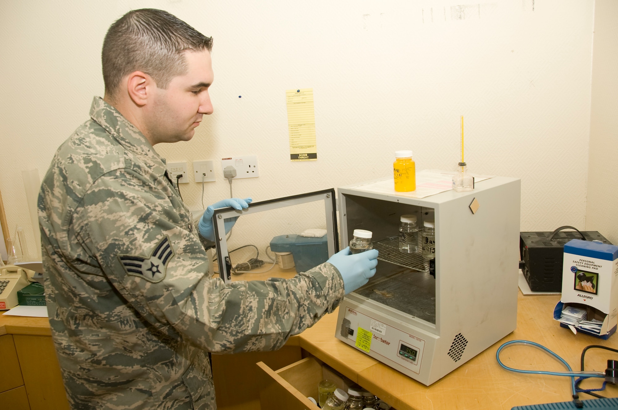 Senior Airman Ryan Smith, 379th Expeditionary Medical Group Bioenvironmental environmental program manager, places a bottled water sample into an incubator July 20, 2012 here. The test is conducted to help grow any potential bacteria which may be found in the water. More than 1.3 million bottles of water are consumed at this installation every month. (U.S. Air Force photo/Senior Airman Bryan Swink)