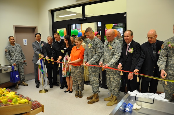 Members of the Defense Commissary Agency, Installation Management Command, the Eighth U.S. Army, and the Far East District cut the ribbon for a new commissary at K-16 Airfield May 17.