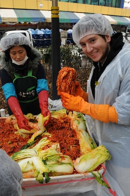 Louis Gud, intern with the U.S. Army Corps of Engineers, Far East District, holds kimchi that he just made. Members of FED volunteered to help make kimchi for local charities Nov. 22 as part of the Good Neighbor Program. (Photo by Patrick Bray)
