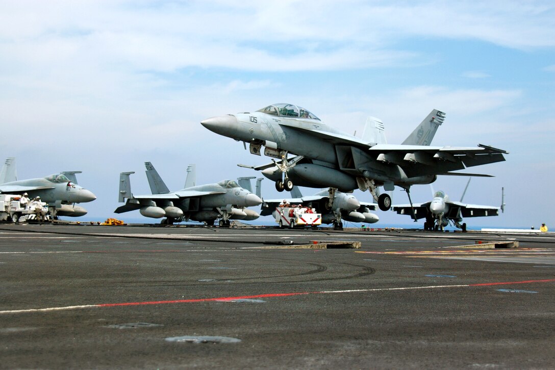 U.S. Navy Capt. Daniel Cave, commander of Carrier Air Wing 5, approaches the flight deck during his last arrested landing on the USS George Washington under way in the Philippine Sea, July 24, 2012.