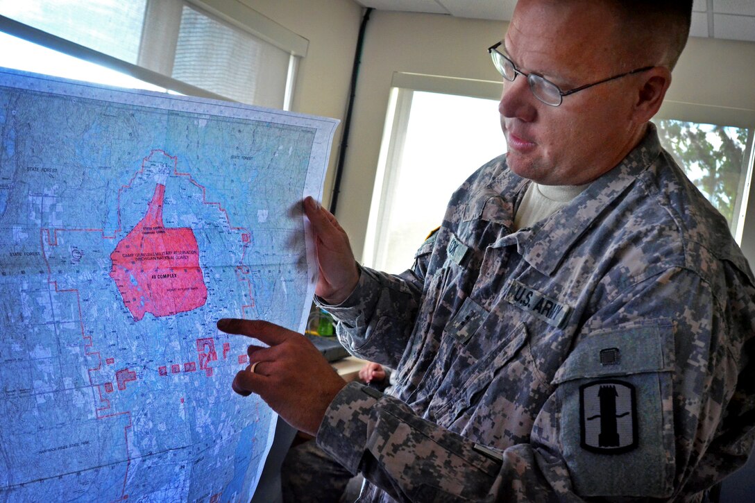 Army Chief Warrant Officer 2 Robert Cook shows on a map where rounds from an 
M777 lightweight howitzer are landing during a live-fire mission on Camp Grayling, Mich., July 20, 2012. Cook is assigned to Company B, 119th Field Artillery, Michigan Army National Guard.