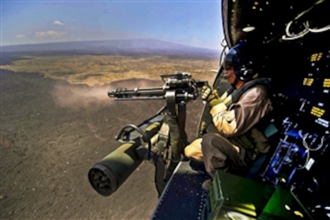 Marine Corps Cpl. Richard Sippl fires a 7.62mm GAU-17/A Minigun during a live-fire combat training mission during the Rim of the Pacific 2012 over the Pohakuloa Training Area in Hawaii, July 22, 2012. The exercise involves 22 nations, more than 40 ships and submarines, more than 200 aircraft and 25,000 personnel.