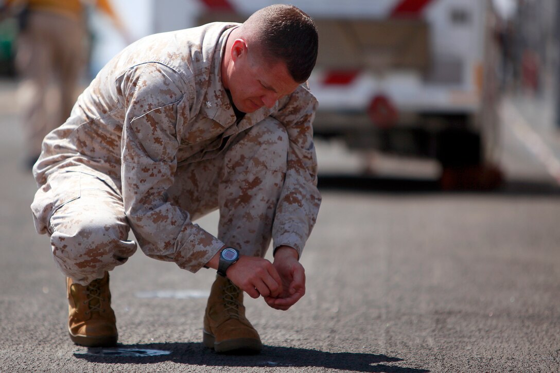 Lieutenant Col. Ned M. Biehl, commanding officer, Marine Medium Helicopter Squadron 364, 15th Marine Expeditionary Unit, picks up some debris during a foreign object and debris walk prior to the day’s flight operations during Composite Training Unit Exercise, July 26. Foreign object and debris walks are performed daily before any flight operations are conducted to ensure there are no loose gravel or debris that could get caught in the engines of the aircraft. The COMPTUEX provides the Peleliu Amphibious Ready Group and 15th MEU with realistic training for their upcoming deployment this fall.