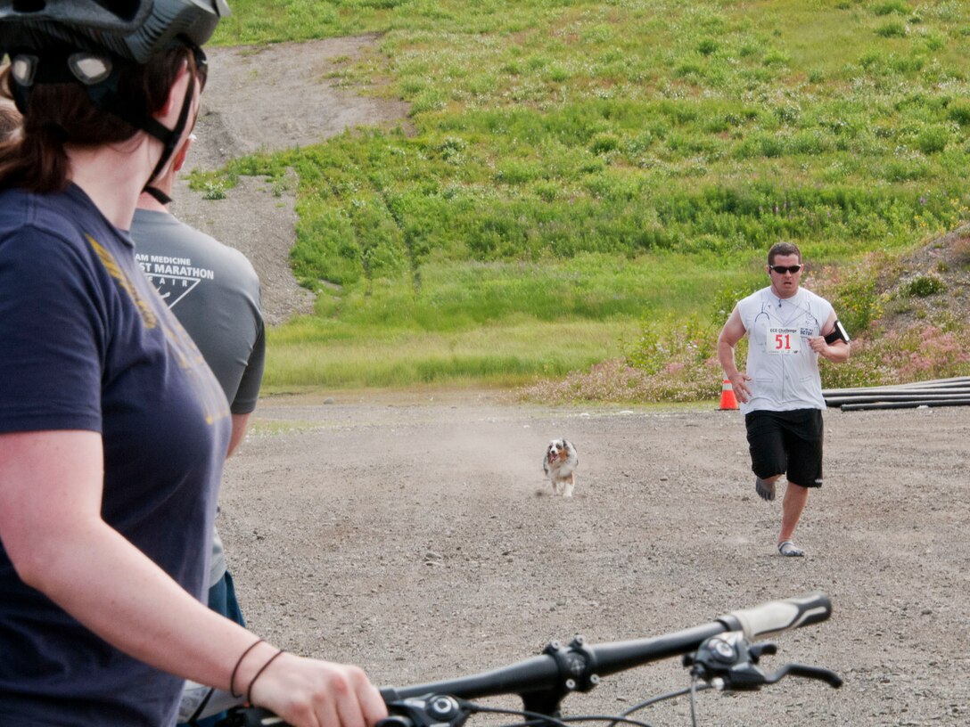 JOINT BASE ELMENDORF-RICHARDSON -- Senior Airman Joel Graff, a cryptological linguist with the 381st Intelligence Squadron, races for the end of the running route here July 20 so his teammate and wife, Amra Graff, could start off on the biking portion. Military and community members across the base participated in the Eco Challenge, an annual, multi-sport event hosted by the base fitness centers. National Guard photo by Staff Sgt. N. Alicia Goldberger.