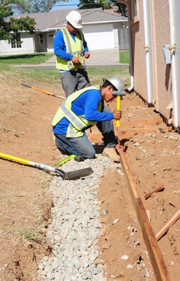 Employees of Barrow's landscaping build rock barriers to put around homes at Beale Air Force Base Calif., July 26, 2012. Rock barriers can be used to help prevent termite infestation. (U.S. Air Force photo by Senior Airman Allen Pollard)
