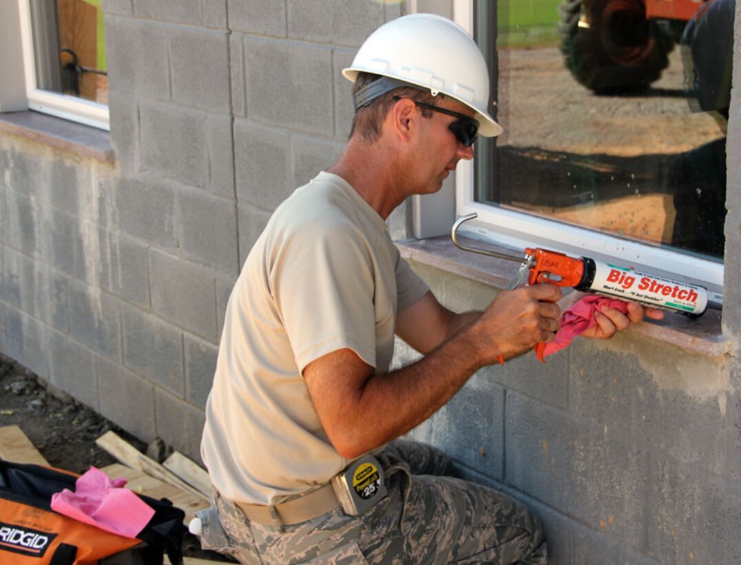 Senior Master Sgt. Kevin Bell applies caulking to windows at the new Riverside Christian Academy fieldhouse in Fayetteville, Tenn.   Bell and other 932nd Civil Engineer Squadron members have been working at the site since mid-July as part of annual training.  The Individual Readiness Training (IRT) is managed by the Air Force Reserve Command  which coordinates military bases and  communities who meet certain fiscal, legal and project requirements.  The IRT allows reservists to use their skills while local communities receive assistance with construction projects. (U.S. Air Force photo/Tech. Sgt. Dan Oliver)