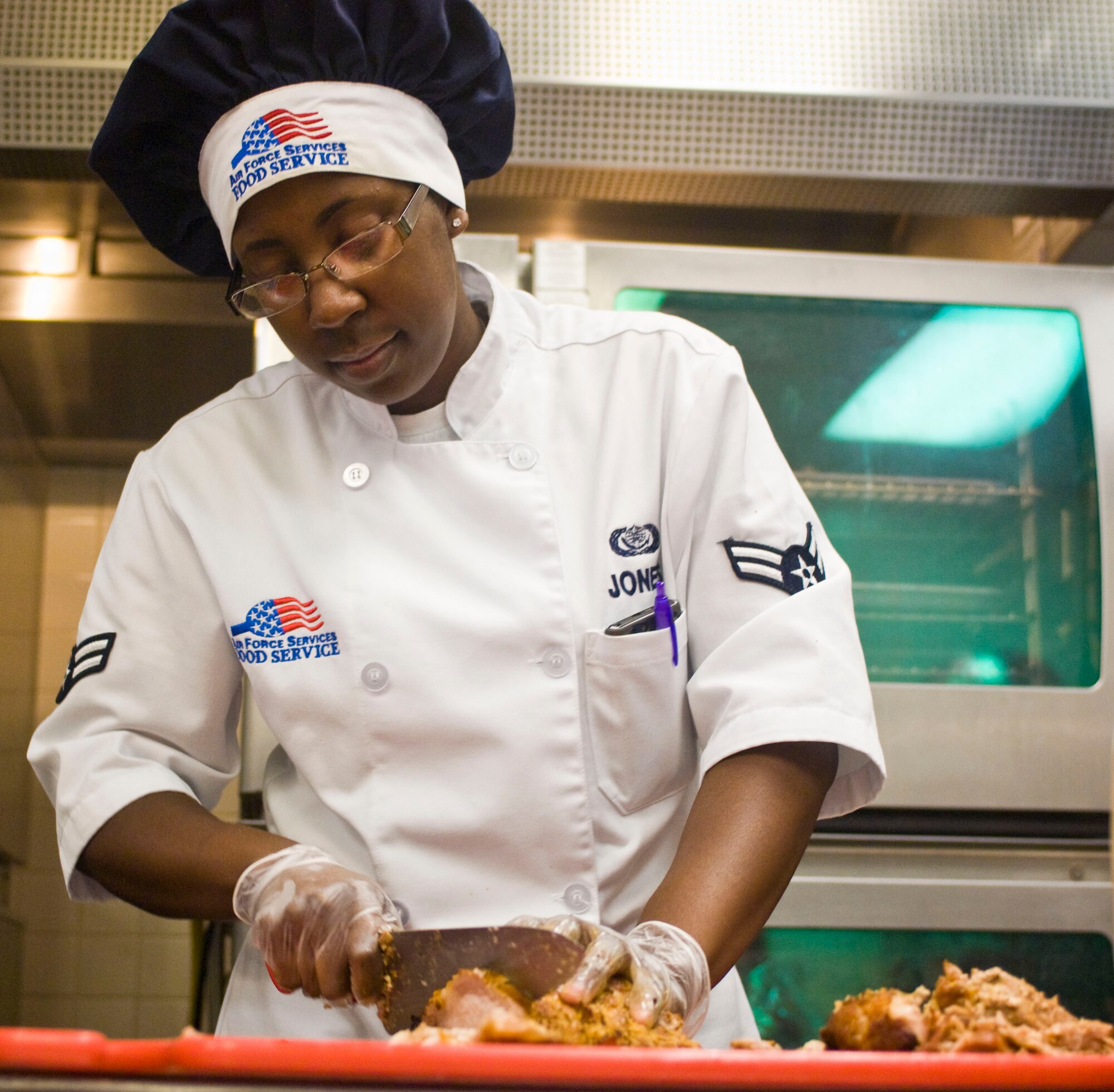 Airman 1st Class Jacqueline Jones, 99th Force Support Squadron food services specialist, slices chicken July 23, 2012, at the Crosswinds Dining Facility on Nellis Air Force Base, Nev. Dining facility Airmen are responsible for ensuring food at the facility is cooked, prepared and served according to Air Force standards. (U.S. Air Force photo by Senior Airman Jack Sanders)
