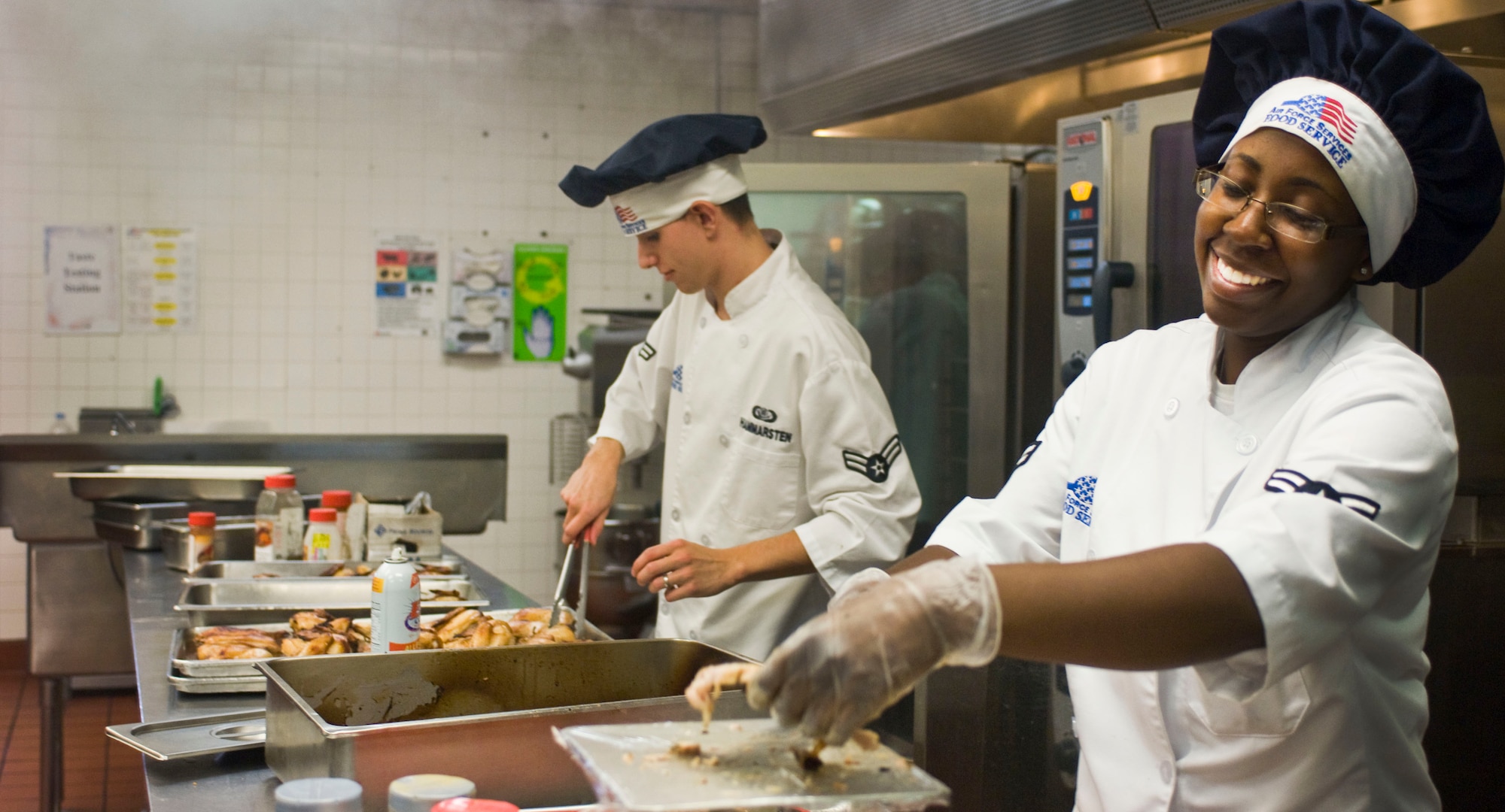 Airman 1st Class Jacqueline Jones and Airman 1st Class Joseph Hammersten, 99th Force Support Squadron food services specialists, prepare lunch July 23, 2012, at the Crosswinds Dining Facility on Nellis Air Force Base, Nev. Dining facility Airmen ensure a balanced menu is in place for patrons according to the Air Force World Wide Menu. (U.S. Air Force photo by Senior Airman Jack Sanders)

