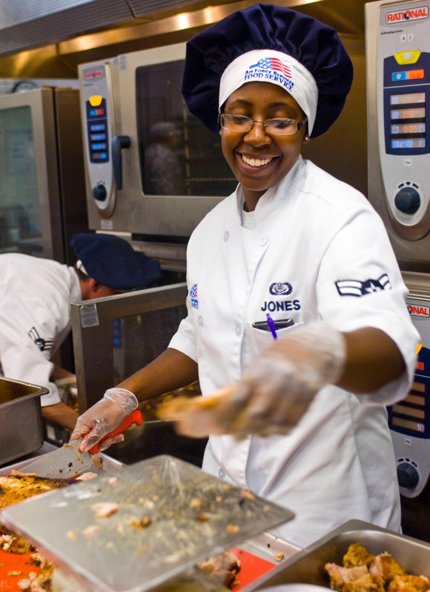 Airman 1st Class Jacqueline Jones, 99th Force Support Squadron food services specialist, prepares chicken July 23, 2012, at the Crosswinds Dining Facility on Nellis Air Force Base, Nev. Food prepared at the dining facility is required to meet Air Force standard and fall under the Air Force World Wide Menu.(U.S. Air Force photo by Senior Airman Jack Sanders)