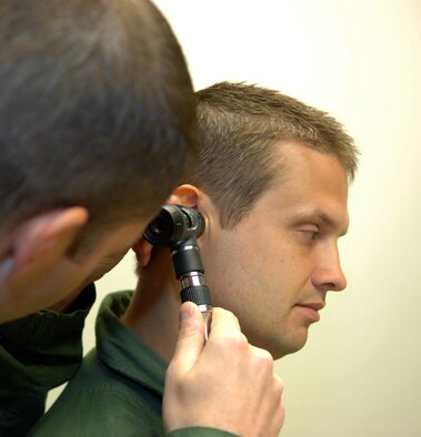 Maj. Adam Newell 2nd Medical Group Flight Medicine, chief, demonstrates looking into the ear of a patient on fellow physician Capt. Frank Janes, 2 MDG Flight Medicine general medical officer, at Barksdale Air Force Base, La., July 26. The annual preventative health assessment is designed to catch any illnesses or medical issues early on so that the flyers can continue to do their part of Barksdale's mission. (U.S. Air Force photo/Staff Sgt. Jason McCasland)(RELEASED) 

