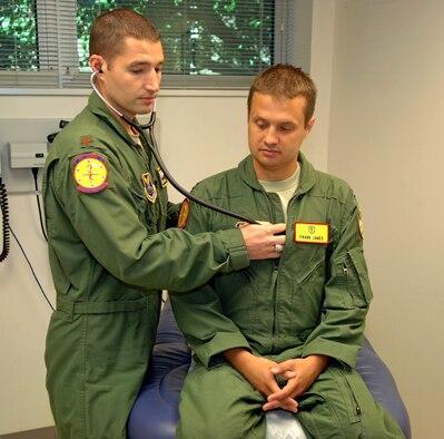 Maj. Adam Newell, 2nd Medical Group Flight Medicine chief, demonstrates listening to the heart of a patient on fellow physician Capt. Frank Janes, 2 MDG Flight Medicine general medical officer, at Barksdale Air Force Base, La., July 26. The flight medicine doctors ensure more than 1,200 flying personnel are fit-to-fly the Barksdale mission. (U.S. Air Force photo/Staff Sgt. Jason McCasland)(RELEASED) 

