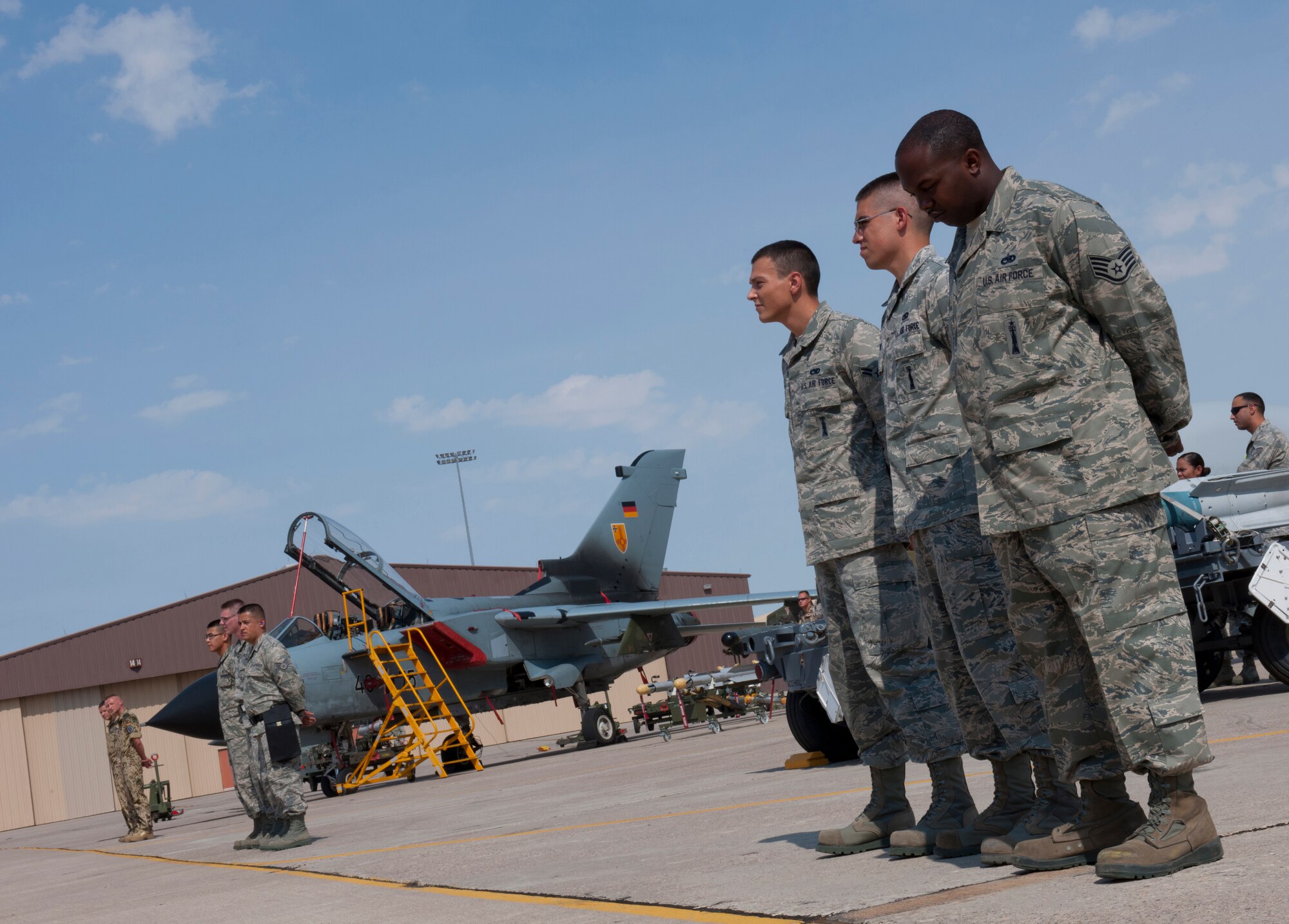 Load crews from the 49th Maintenance Group and the German Air Force Flying Training Center stand in front of their respective aircraft during a quarterly load-crew competition at Holloman Air Force Base, N.M., July 13. Load-crew competitions are held on a quarterly basis and are used to help build morale through friendly competition. (U.S. Air Force photo by Airman 1st Class Michael Shoemaker)