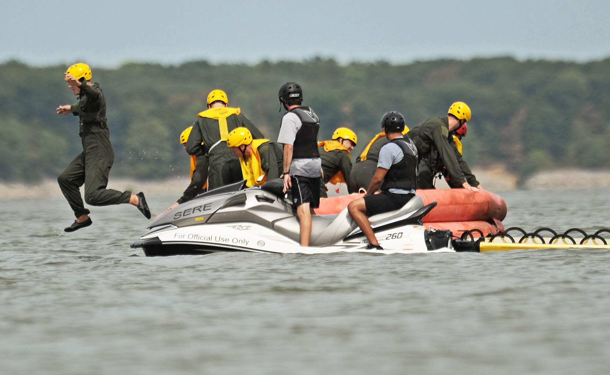 Aircrew members from Scott Air Force Base jump out of a 20-man life raft as they prepare to being the swim portion of their water survival training July 26, 2012 at Carlyle Lake, Ill. A survival, evasion, resistance, escape specialist along with six other volunteers conducted water survival training for nine aircrew members who are required to complete a refresher course every three years to maintain their flight status. (U.S. Air Force photo/ Staff Sgt. Ryan Crane)