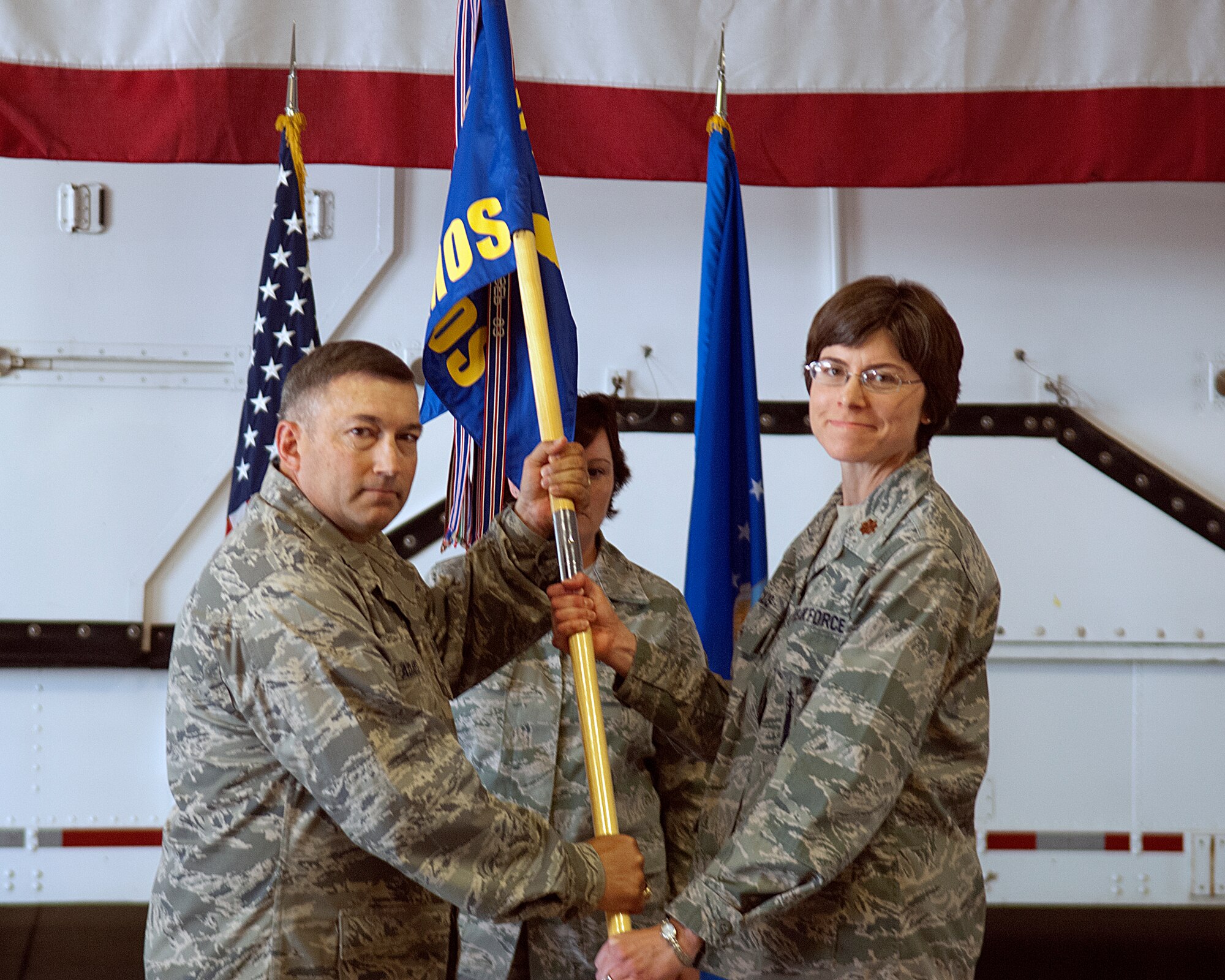 Col. Don Adams, 90th Maintenance Group commander, presents Maj. Margaret Vencius with the 90th Maintenance Operations Squadron guidon, during the squadron’s change-of-command ceremony July 18 on F. E. Warren Air Force Base, Wyo. Vencius assumed the command from Lt. Col. Thomas Vance. (U.S. Air Force photo by R.J. Oriez)