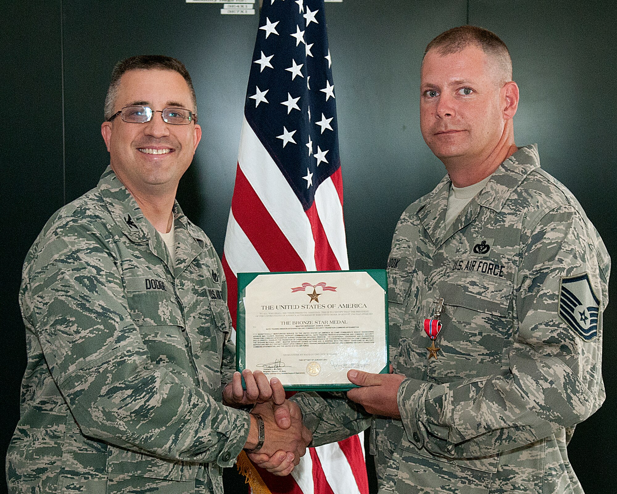 Col. Timothy Dodge, 90th Mission Support Group commander, presents Master Sgt. John Cook, 90th Civil Engineer Squadron, with the Bronze Star Medal July 19. Cook was awarded the medal for his service in Afghanistan. (U.S. Air Force photo by R.J. Oriez)