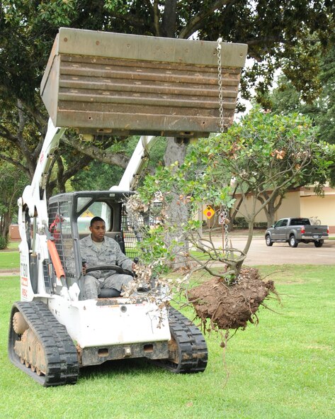 Tech. Sgt. Dontavious Barber, 2nd Civil Engineer Squadron assistant NCO in charge, removes a bush from the 2nd Bomb Wing Headquarters lawn on Barksdale Air Force Base, La., July 27. Several of the bushes were dead or dying and needed to be removed. (U.S. Air Force photo/Senior Airman Sean Martin) (RELEASED)