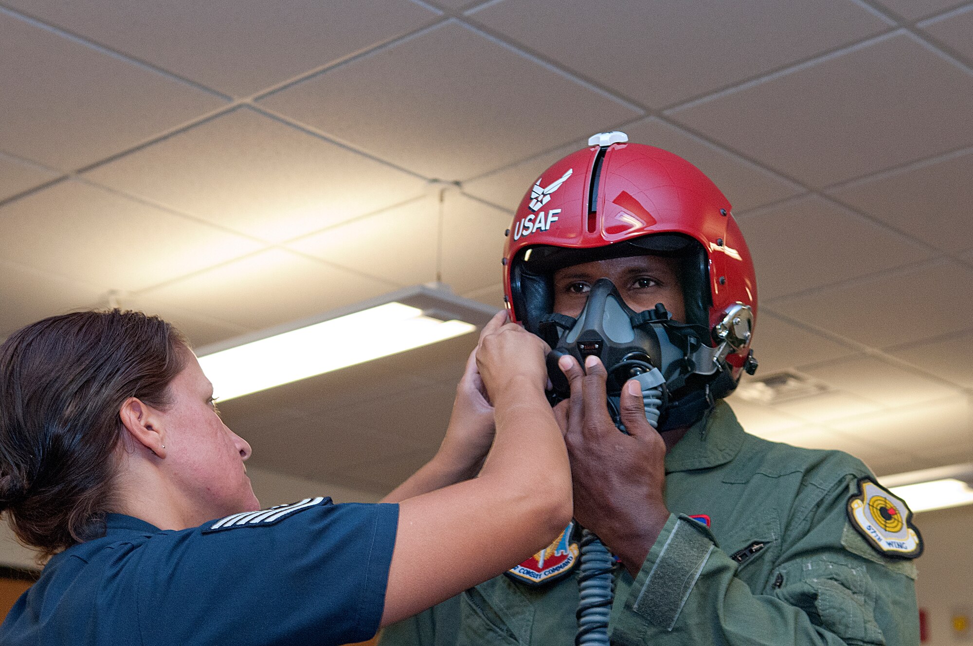 Tech. Sgt. Amber Alumbe, U.S. Air Force Thunderbirds, helps Champ Bailey with his face mask and helmet prior to his flight with the Thunderbirds July 23 in Cheyenne, Wyo. The Denver Broncos all-pro cornerback flew with the aerial demonstration team as they prepared for their show in Cheyenne July 25. The air show has been one of the highlights of the annual Cheyenne Frontier Days for more than 50 years. (U.S. Air Force photo by R.J. Oriez) 