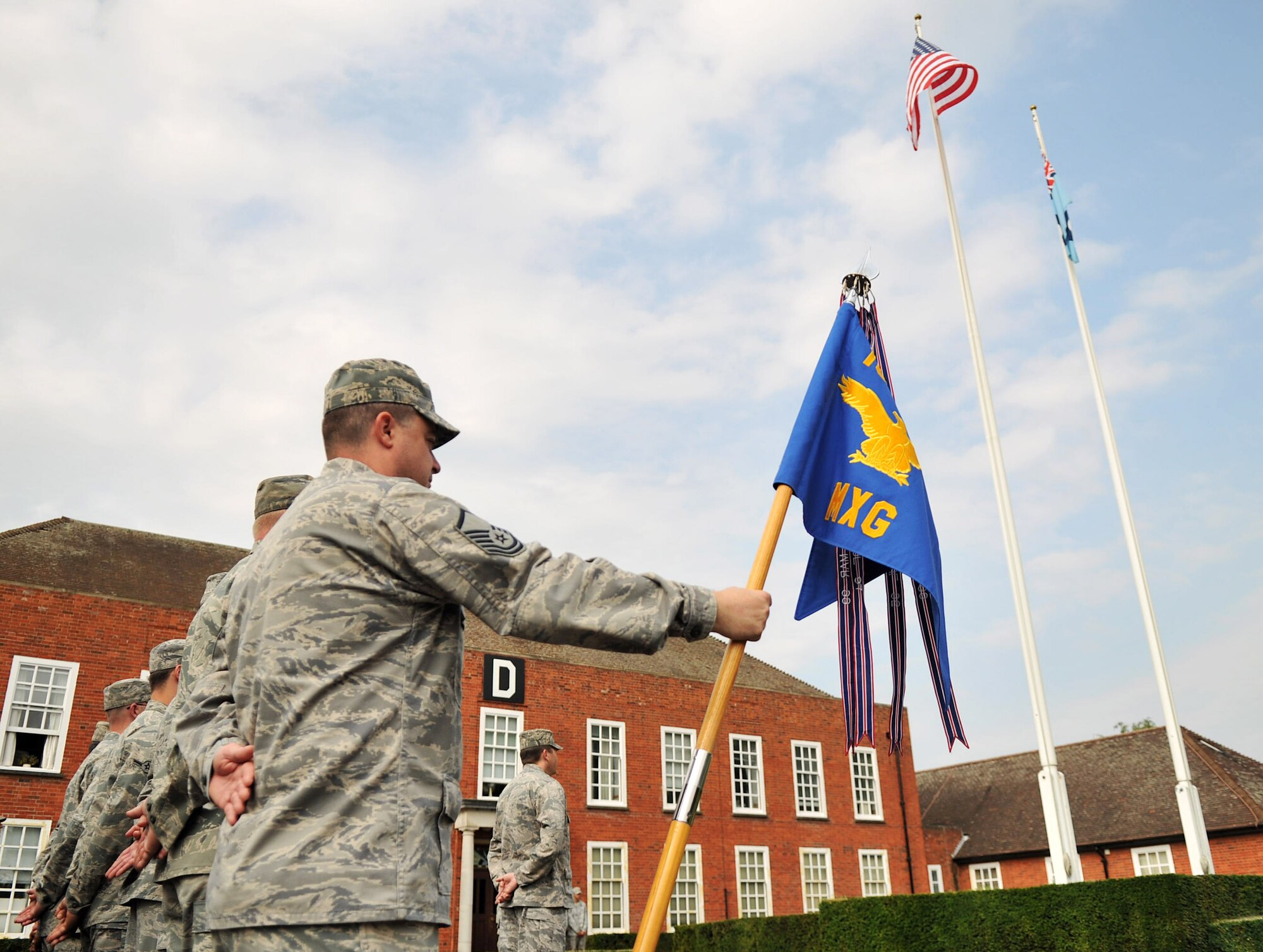 RAF MILDENHALL, England – Airmen from the 100th Maintenance Group stand at parade rest prior to the playing of the U.K. and U.S. national anthems on RAF Mildenhall July 27, 2012. A retreat ceremony, during which the U.S. and Royal Air Force flags are retired, takes place on the last duty day of every month. (U.S. Air Force photo/Senior Airman Jerilyn Quintanilla)